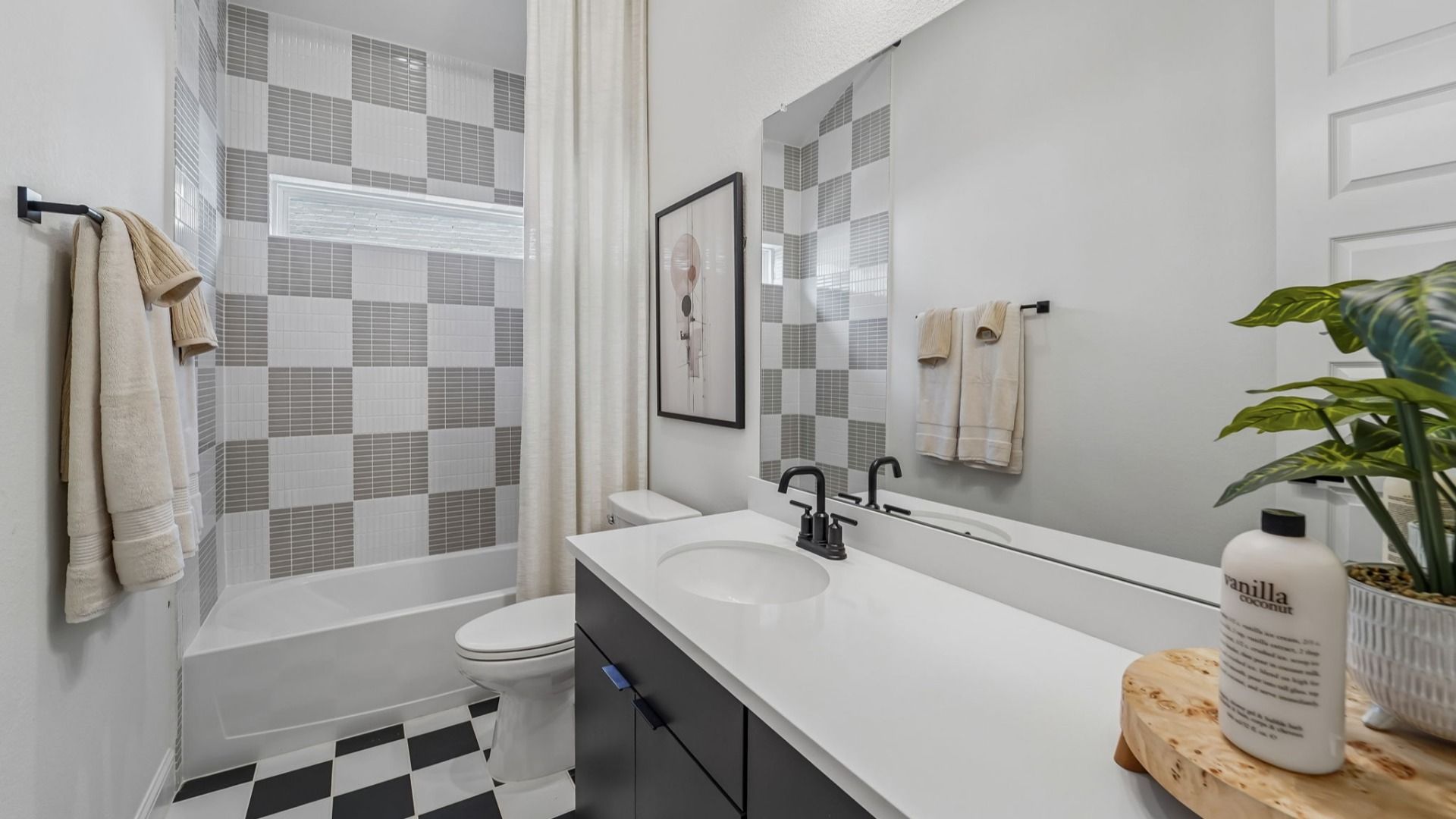Experience sophistication in this exquisite bathroom featuring sleek checkered tiles and elegant fixtures in Woodlands Hills.