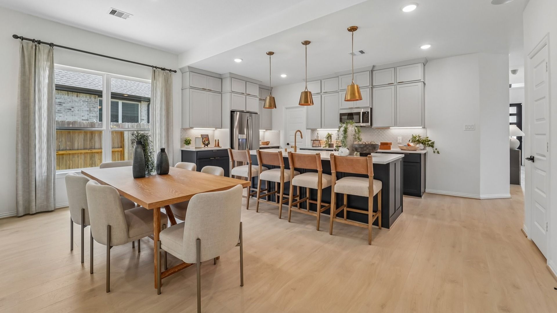 Experience luxury in The Woodlands Hills with sleek cabinetry, elegant pendant lighting, and refined wood flooring.