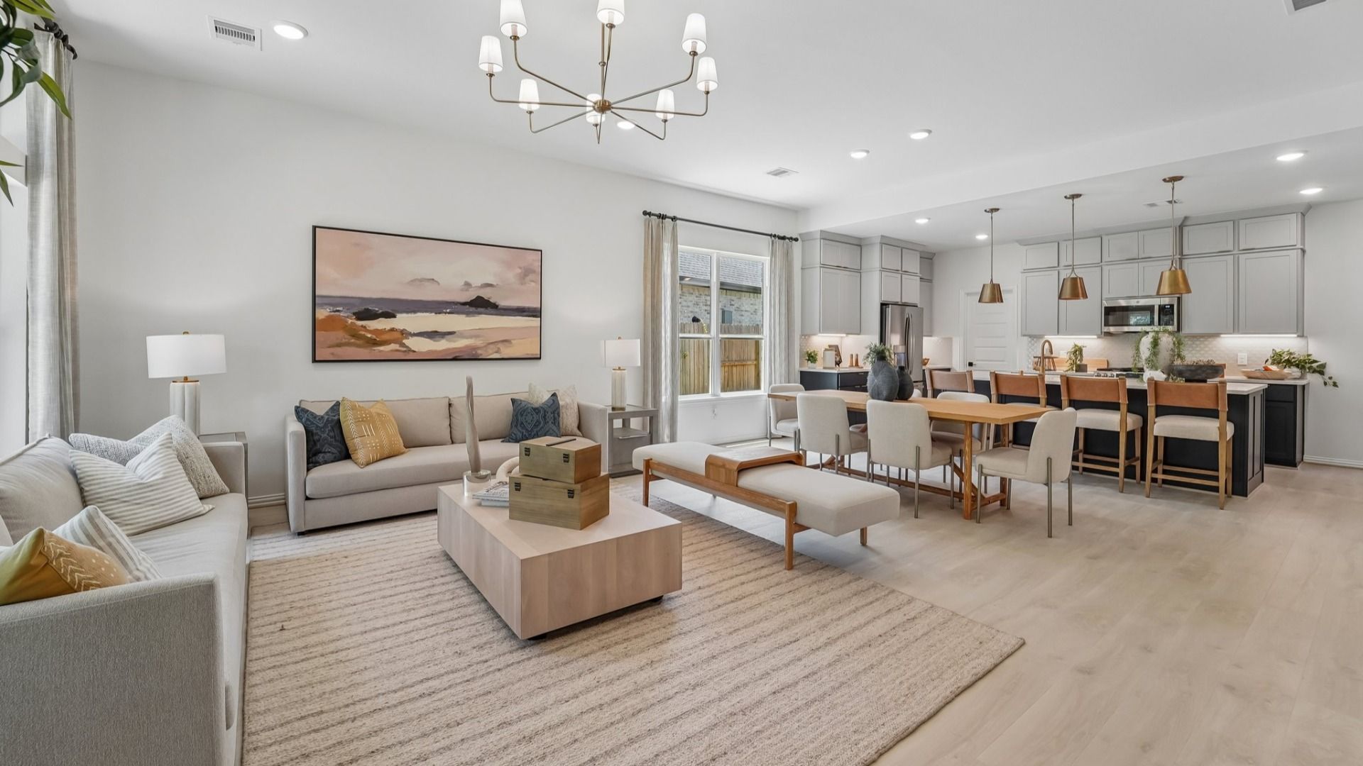 Luxurious open-plan living with chic chandelier and sleek design in The Woodlands Hills.