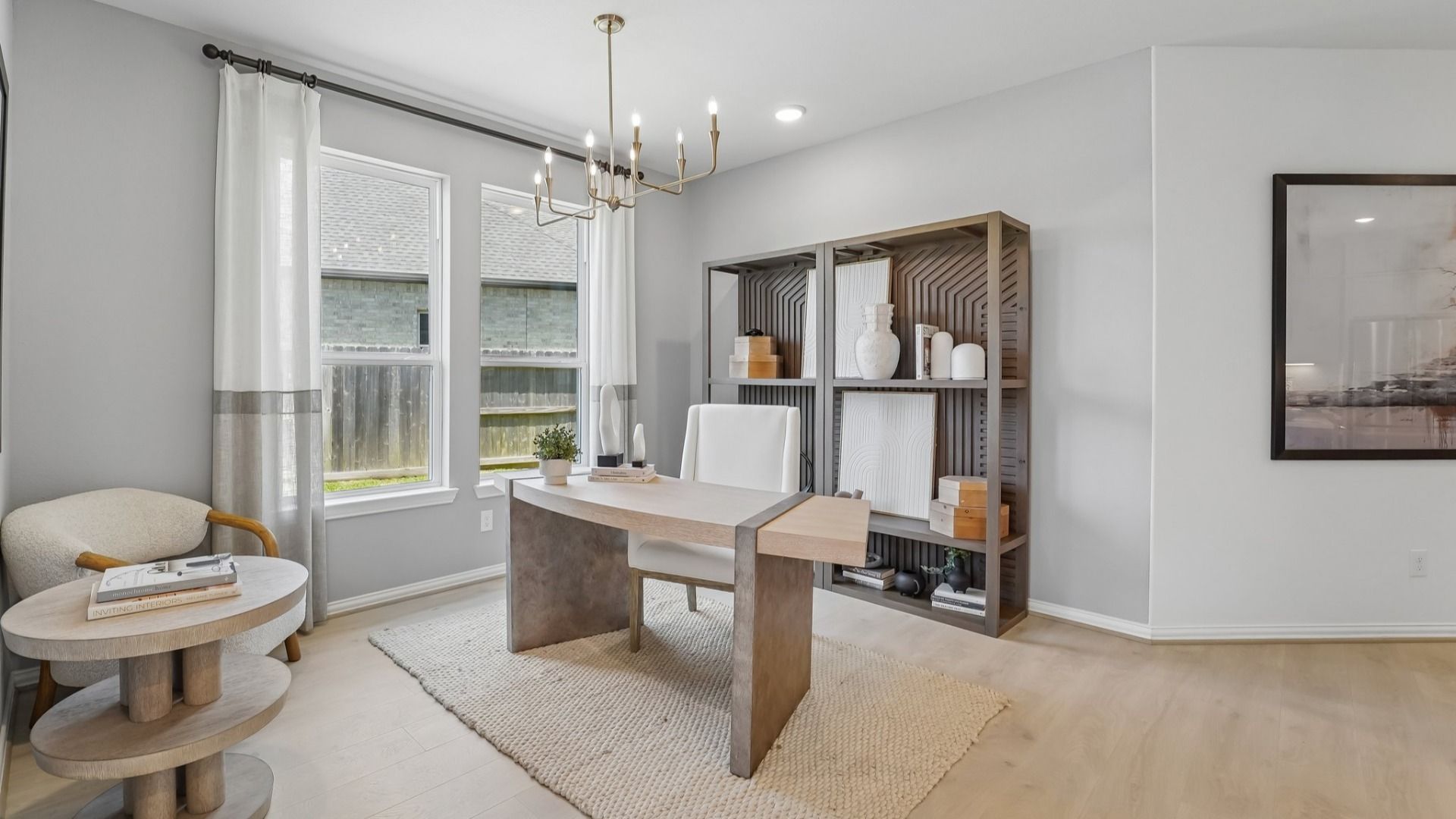 Luxurious office space with chic chandelier, expansive windows, and sleek shelving in The Woodlands Hills.