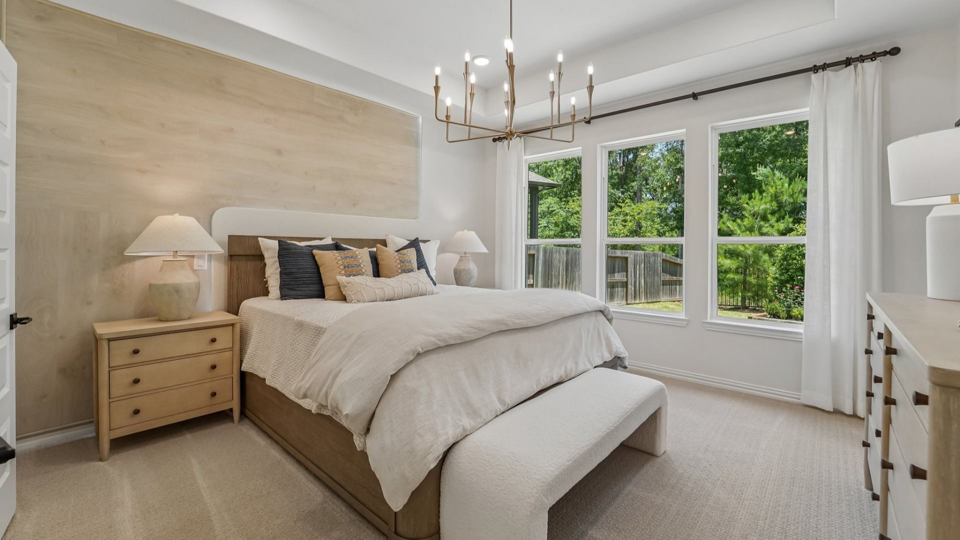 Experience refined elegance with a grand chandelier and expansive windows in The Woodlands Hills.