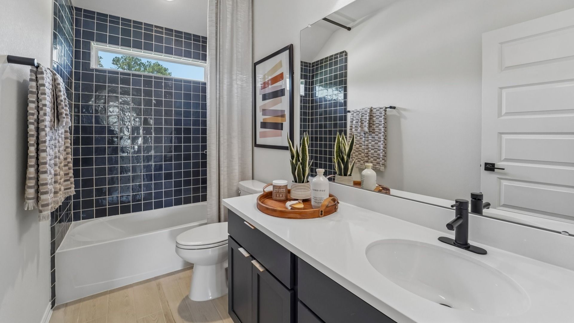 Luxurious bathroom features sleek black tiles and elegant white countertop, creating a chic in Woodlands Hills.