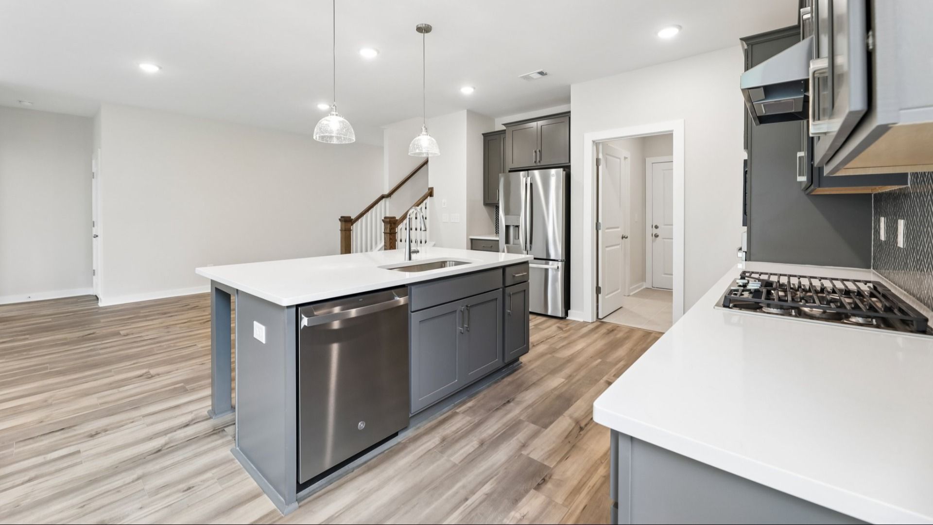 Kitchen with hard surface flooring, quartz countertops, and pendant lighting