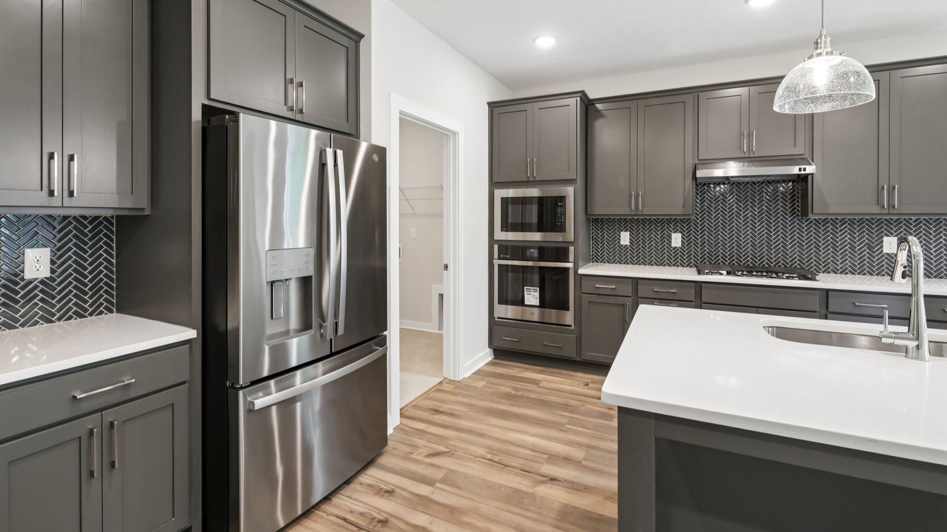 Kitchen with hard surface flooring, quartz countertops, and pendant lighting