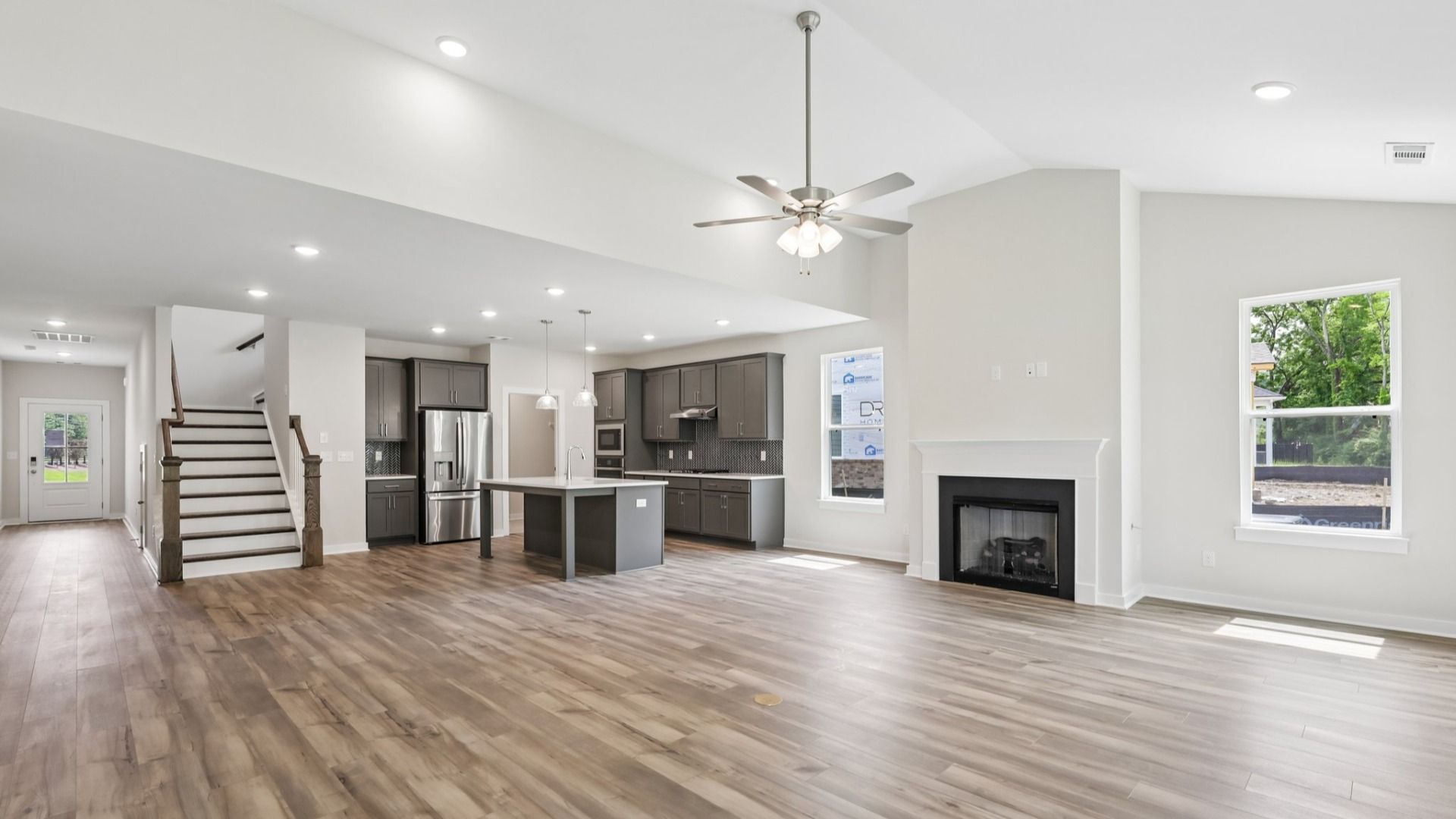 View of kitchen, gathering room, and staircase