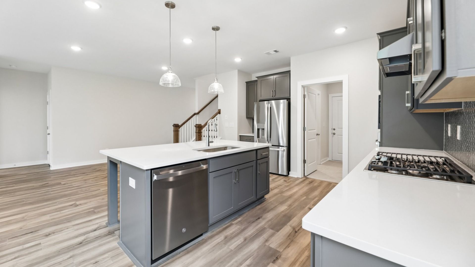 Kitchen with quarts countertops, pendant lighting, and hard surface flooring