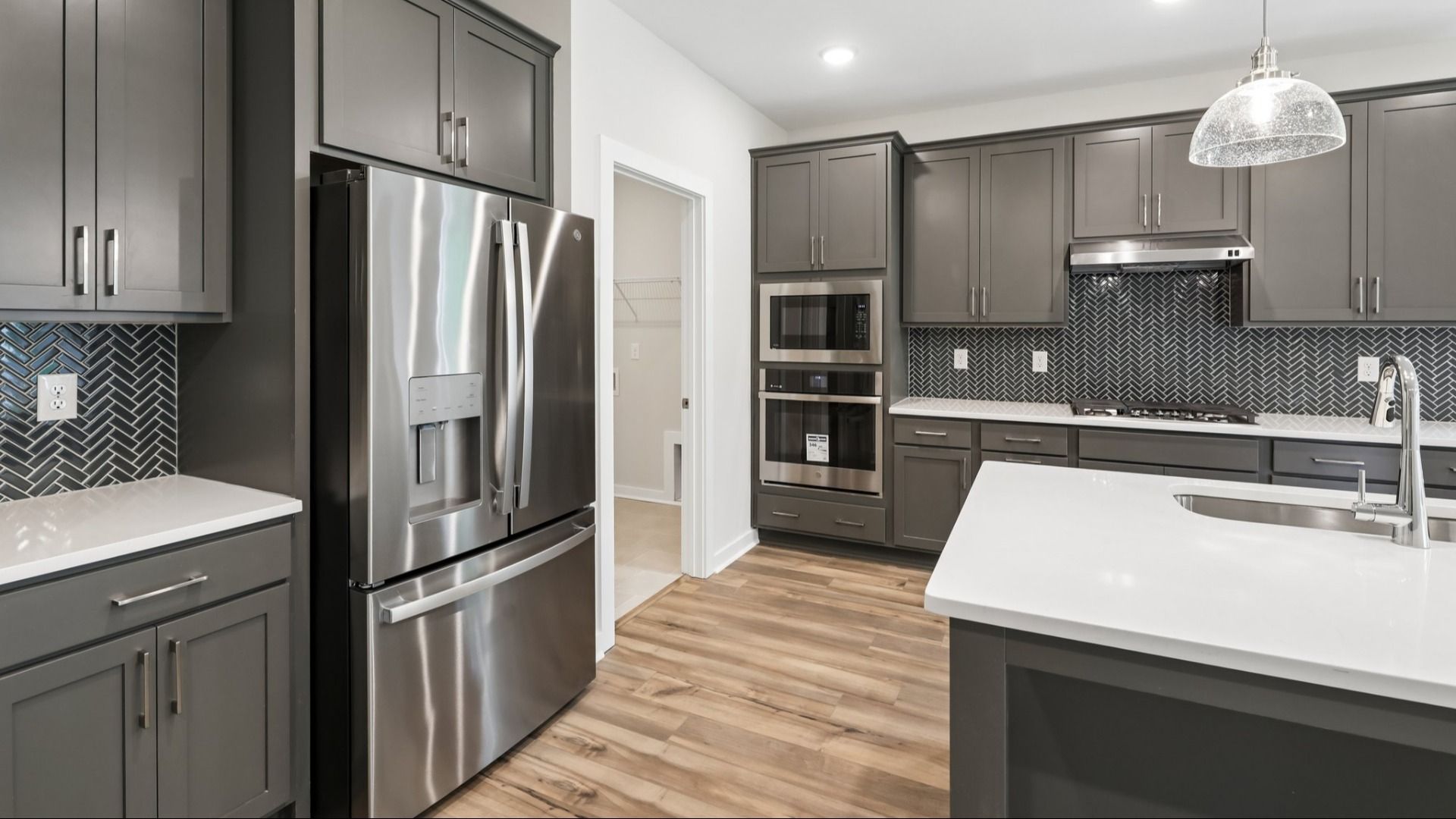 Kitchen with quarts countertops, pendant lighting, and hard surface flooring