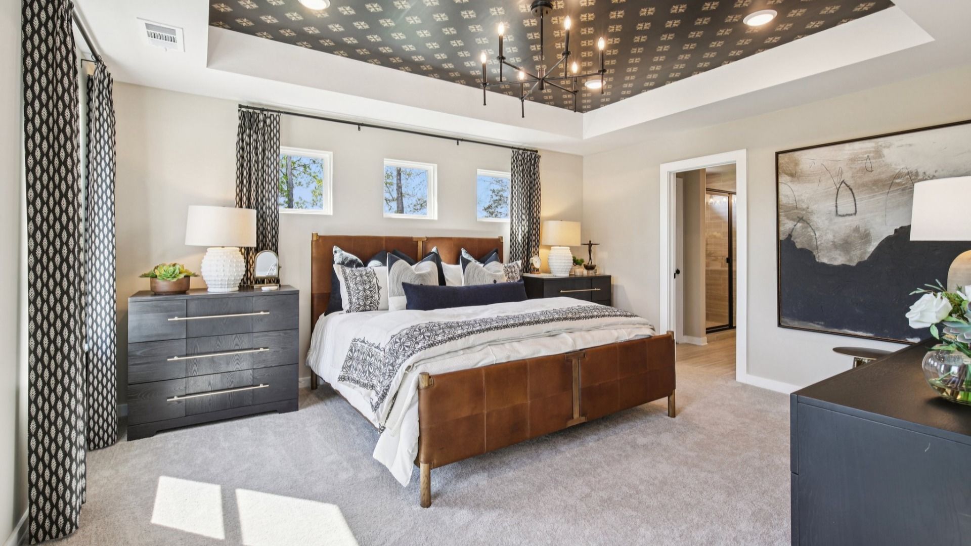 Bedroom with tray ceiling and natural light from windows