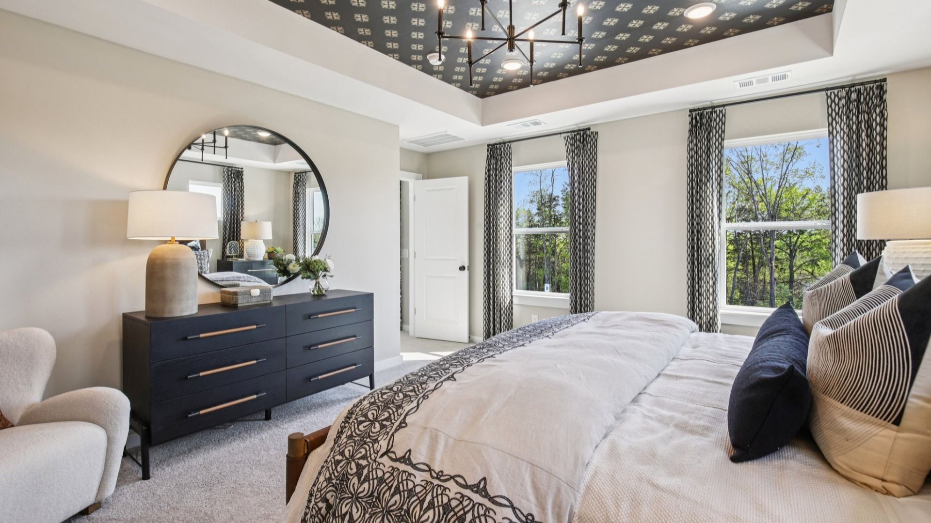 Bedroom with tray ceiling and natural light from windows