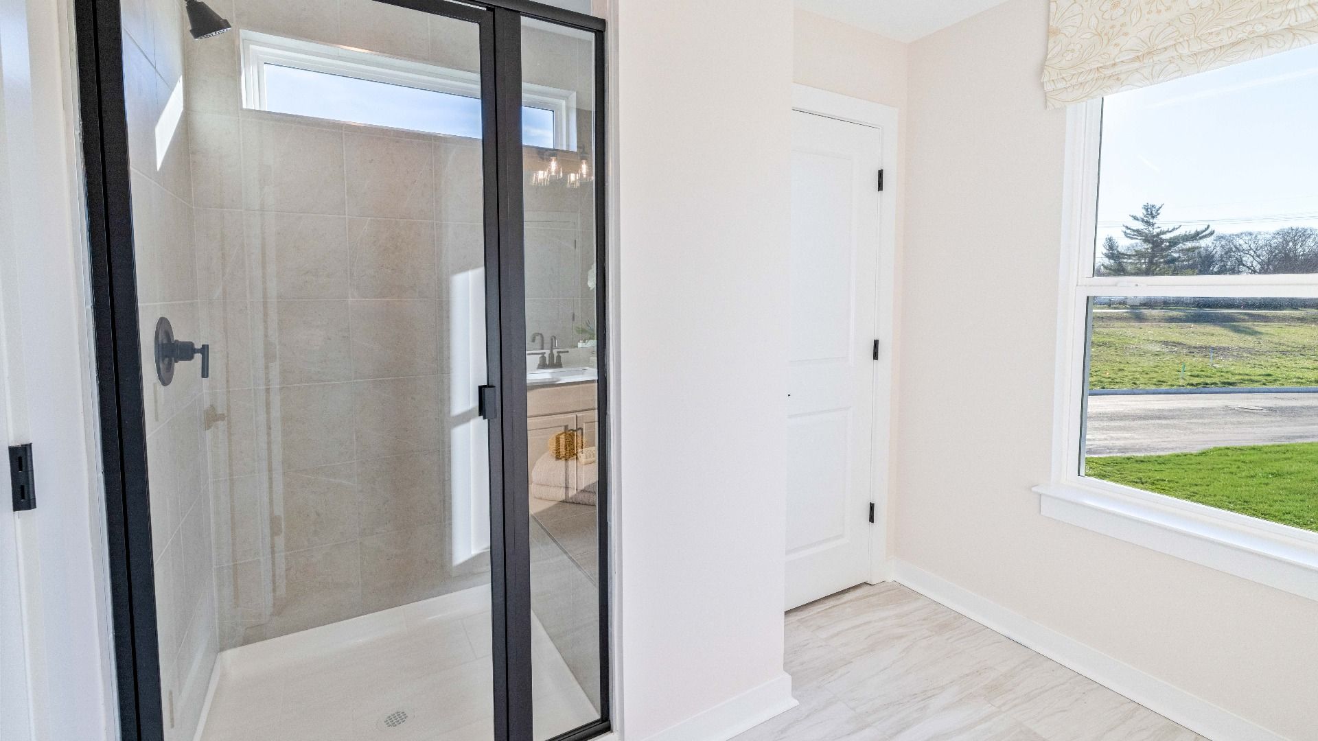Bathroom with window and glass enclosed shower