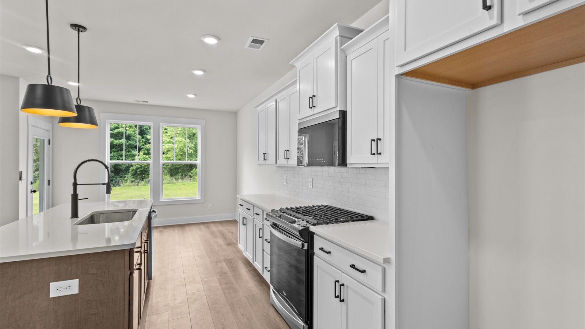 Kitchen with quartz countertops, pendant lighting, and hard surface flooring