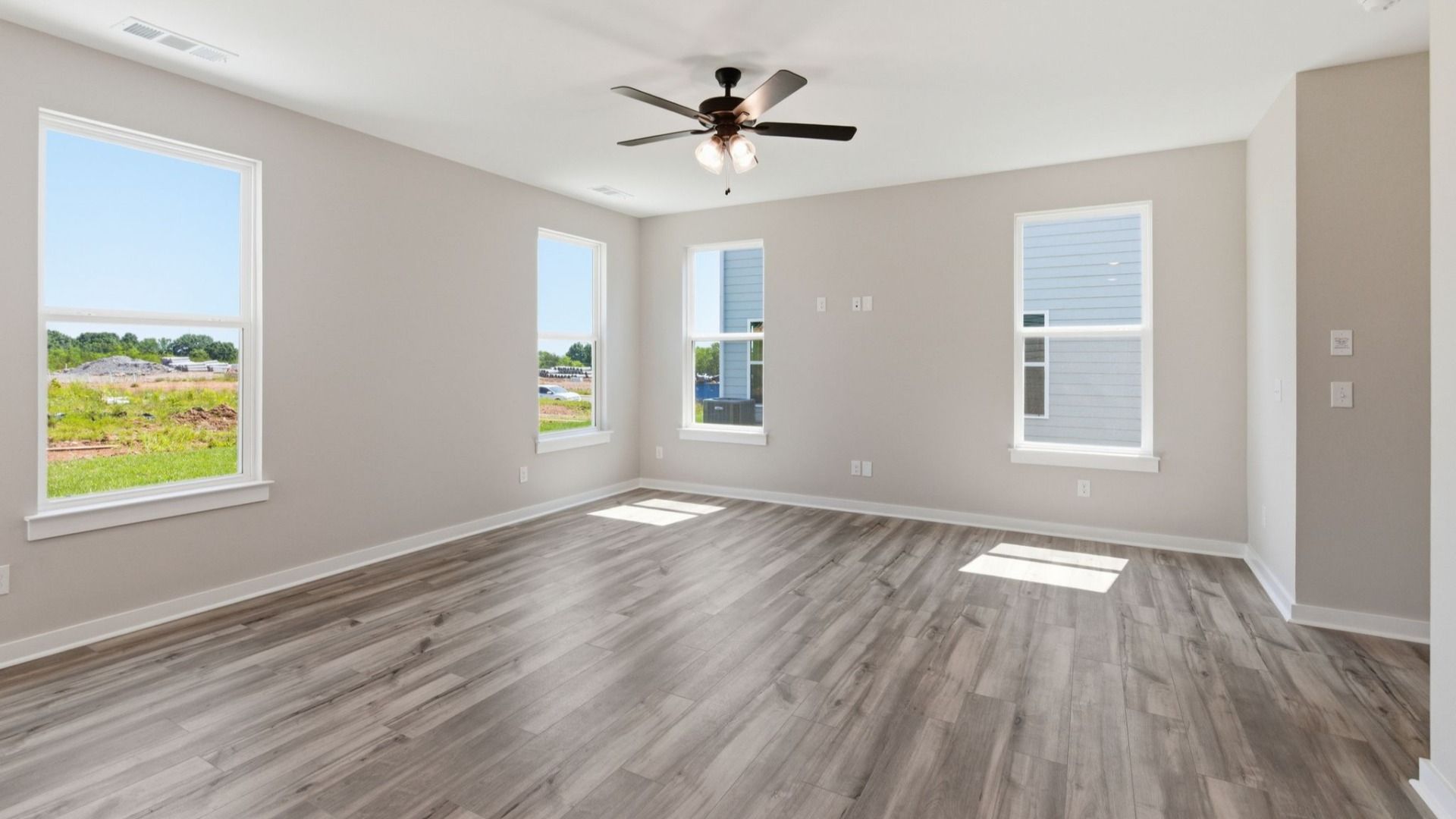 Gathering room with hard surface flooring, windows, and ceiling fan