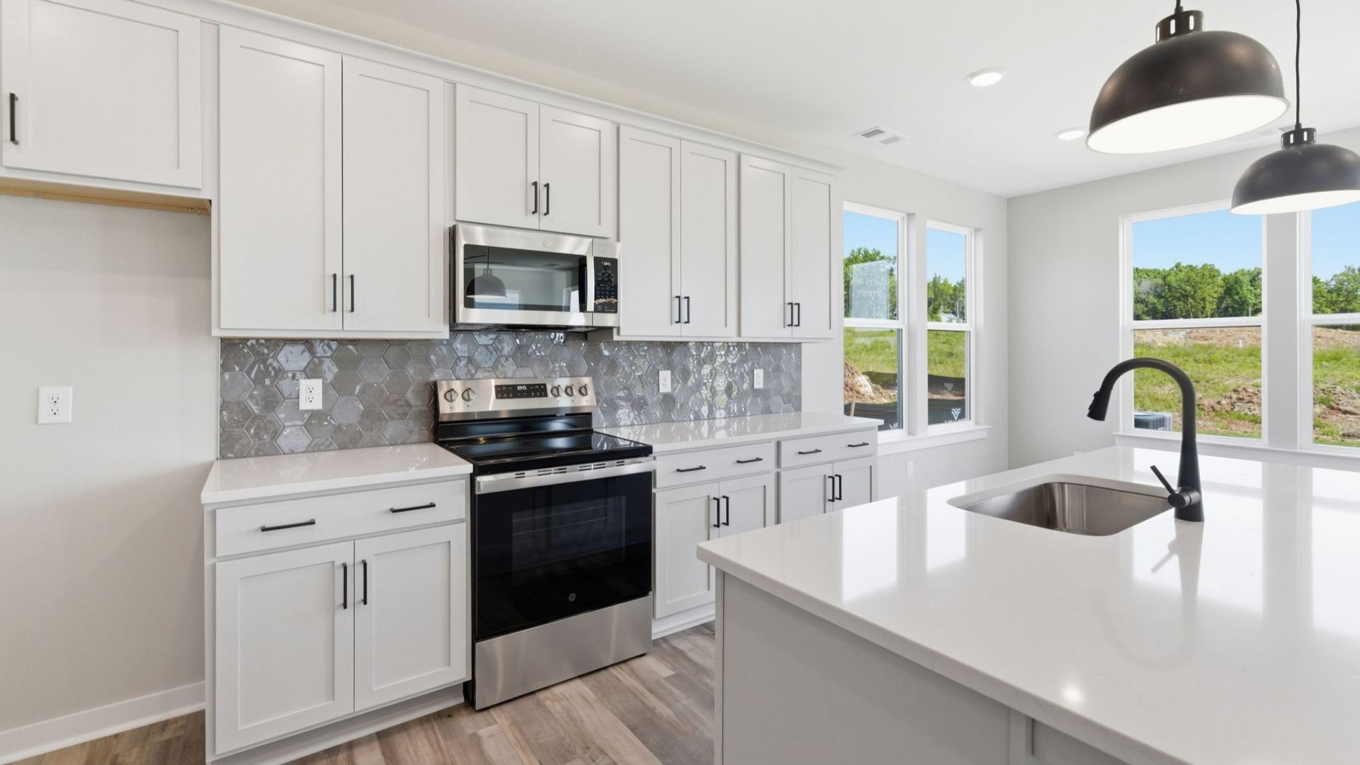 Kitchen with tile backsplash, pendant lighting, and quartz countertops