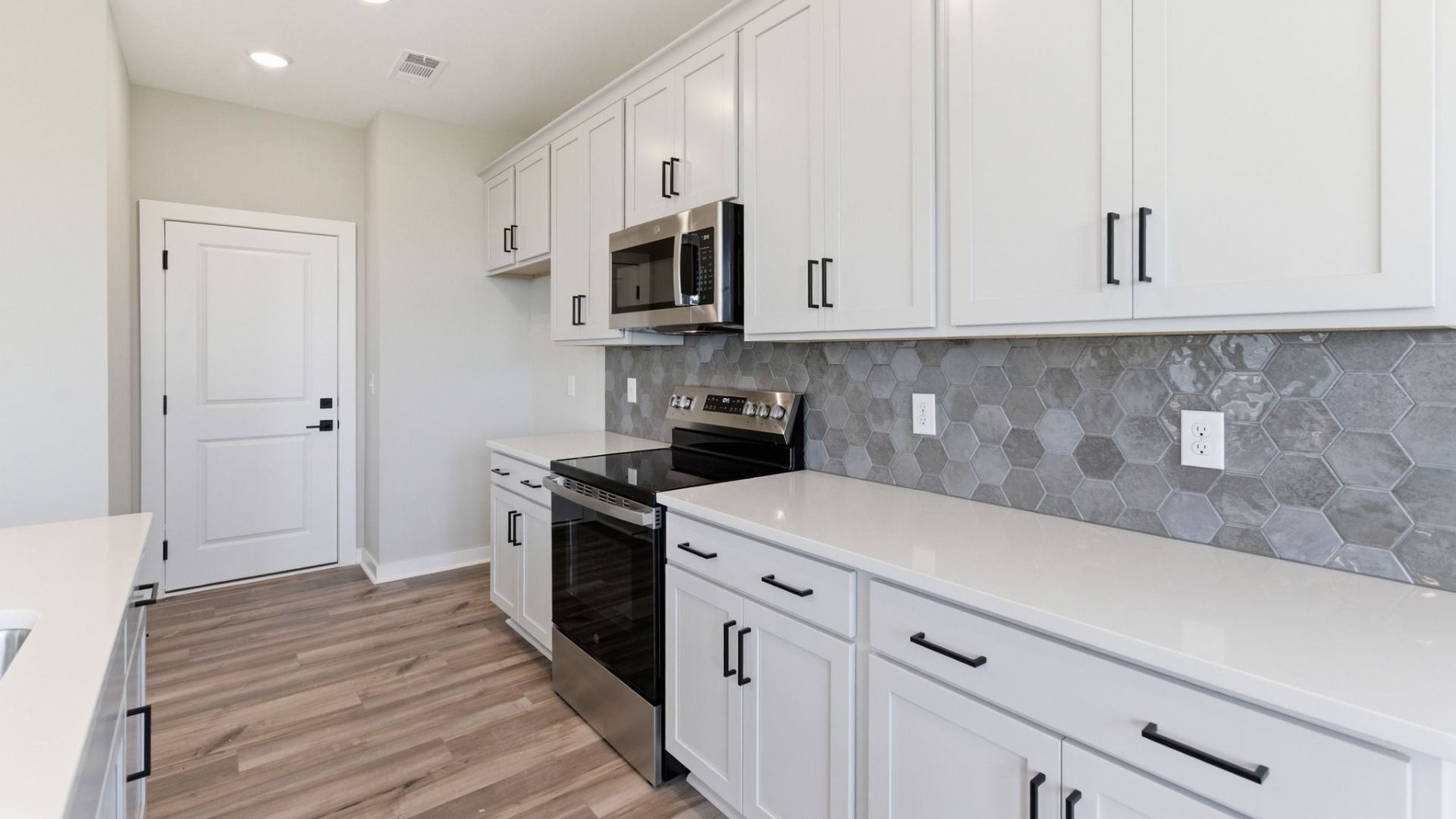 Kitchen with tile backsplash, pendant lighting, and quartz countertops