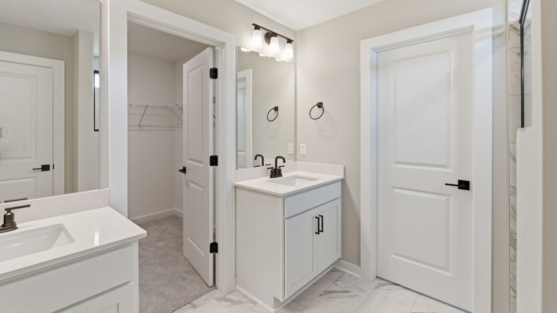 Bathroom with dual vanity and access to primary closet