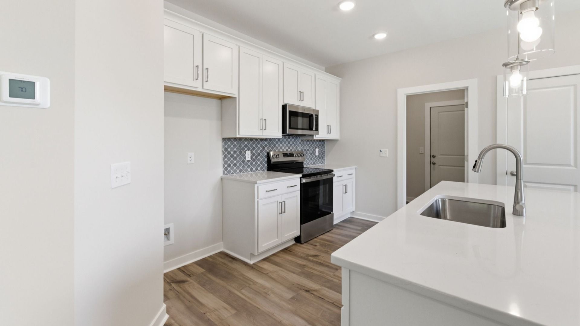Kitchen with tile backsplash, pendant lighting, and quartz countertops