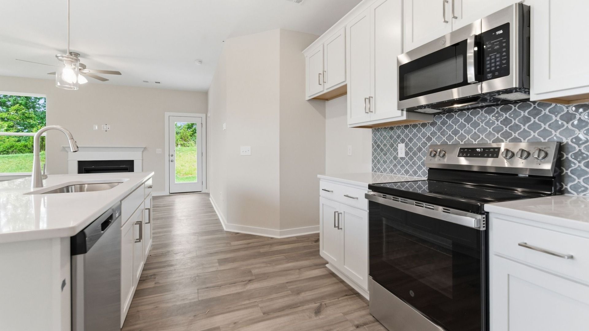 Kitchen with tile backsplash, pendant lighting, and quartz countertops