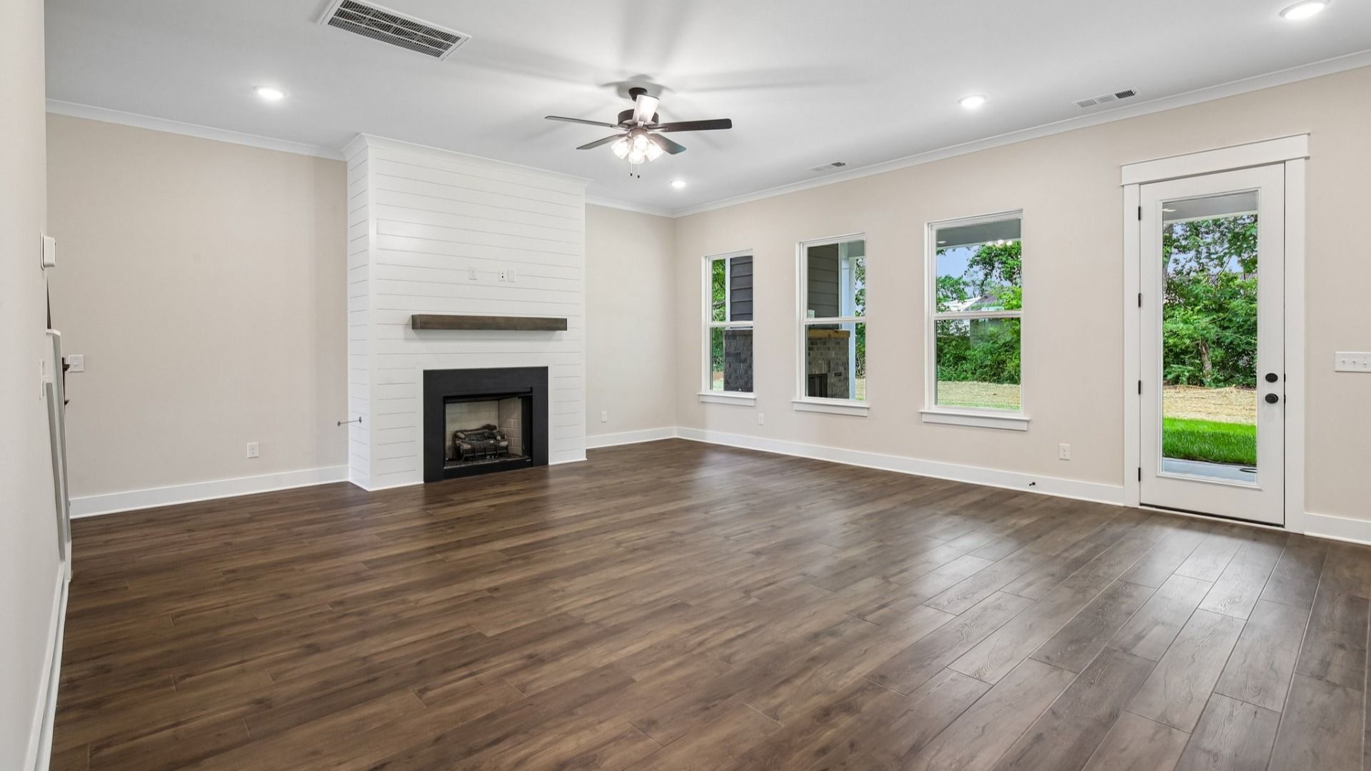 Gathering room with ceiling fan, fireplace, and hard surface flooring