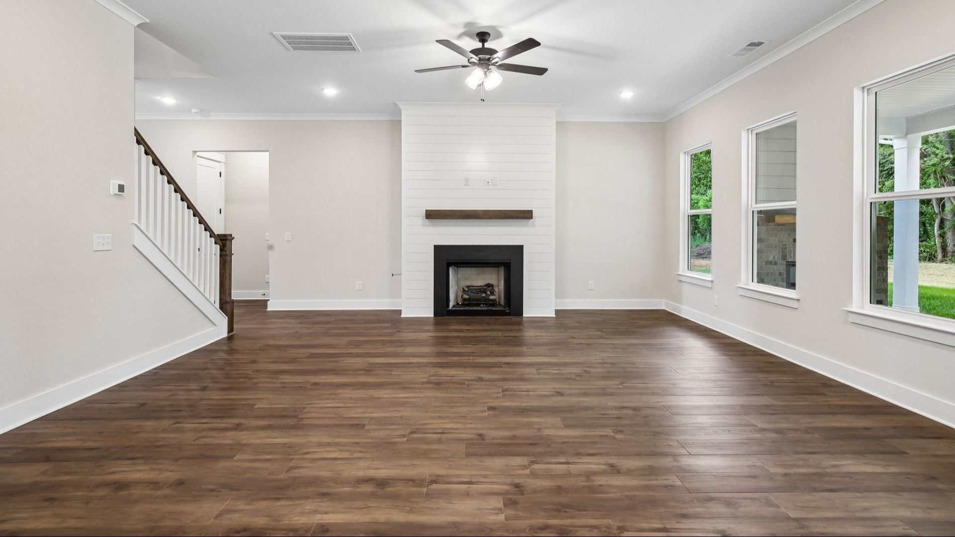 Gathering room with ceiling fan, fireplace, and hard surface flooring