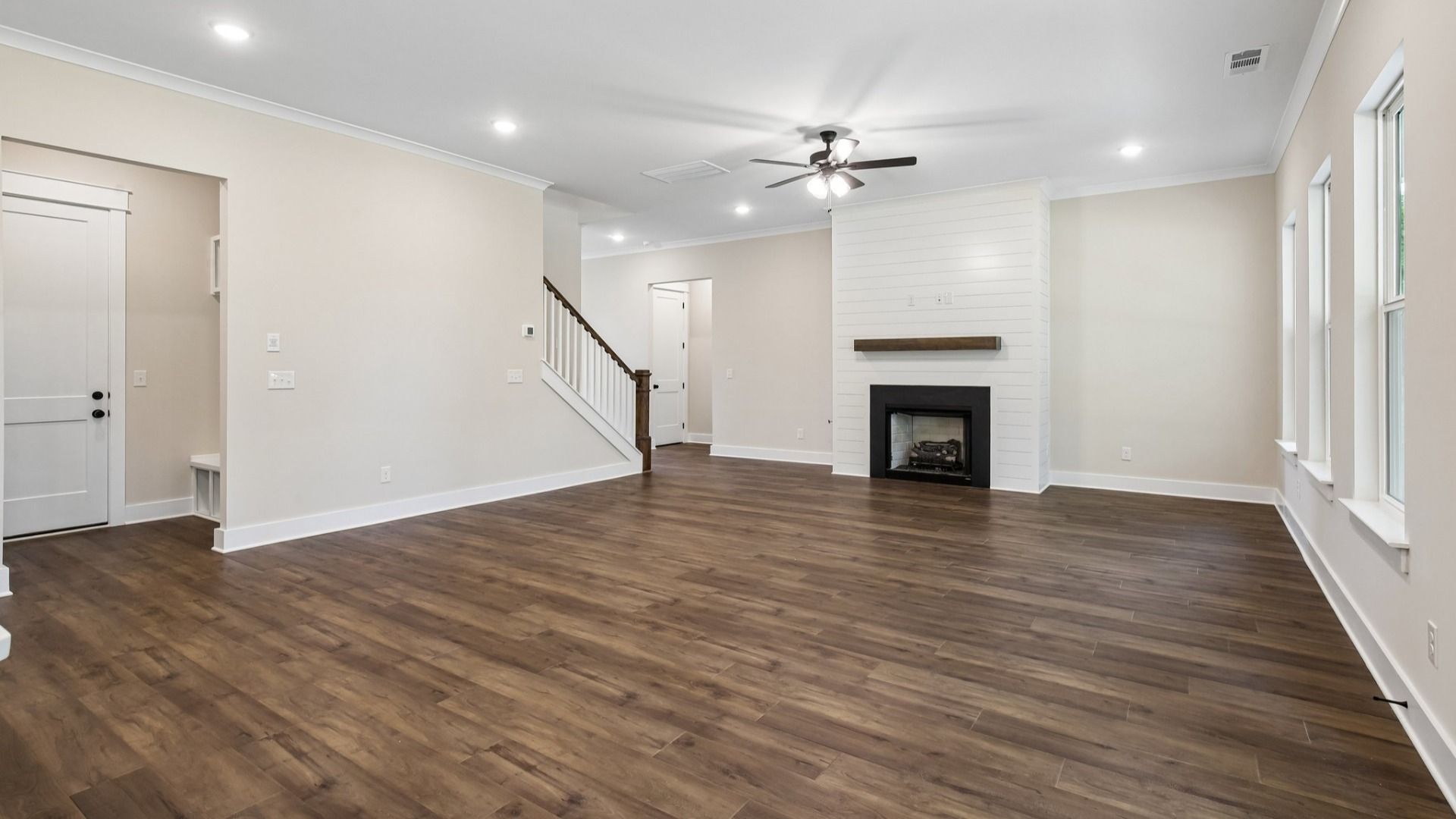 Gathering room with ceiling fan, fireplace, and hard surface flooring