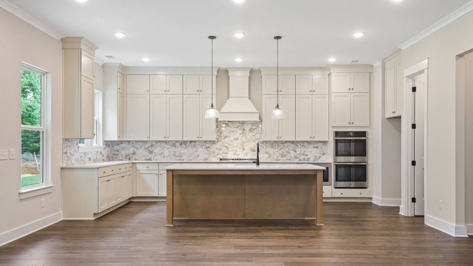 Kitchen with quartz countertops, tile backsplash, and pendant lighting