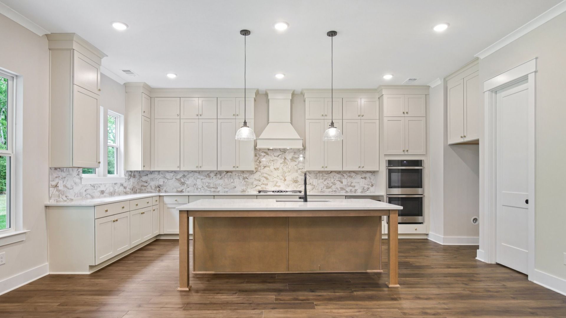 Kitchen with quartz countertops, tile backsplash, and pendant lighting