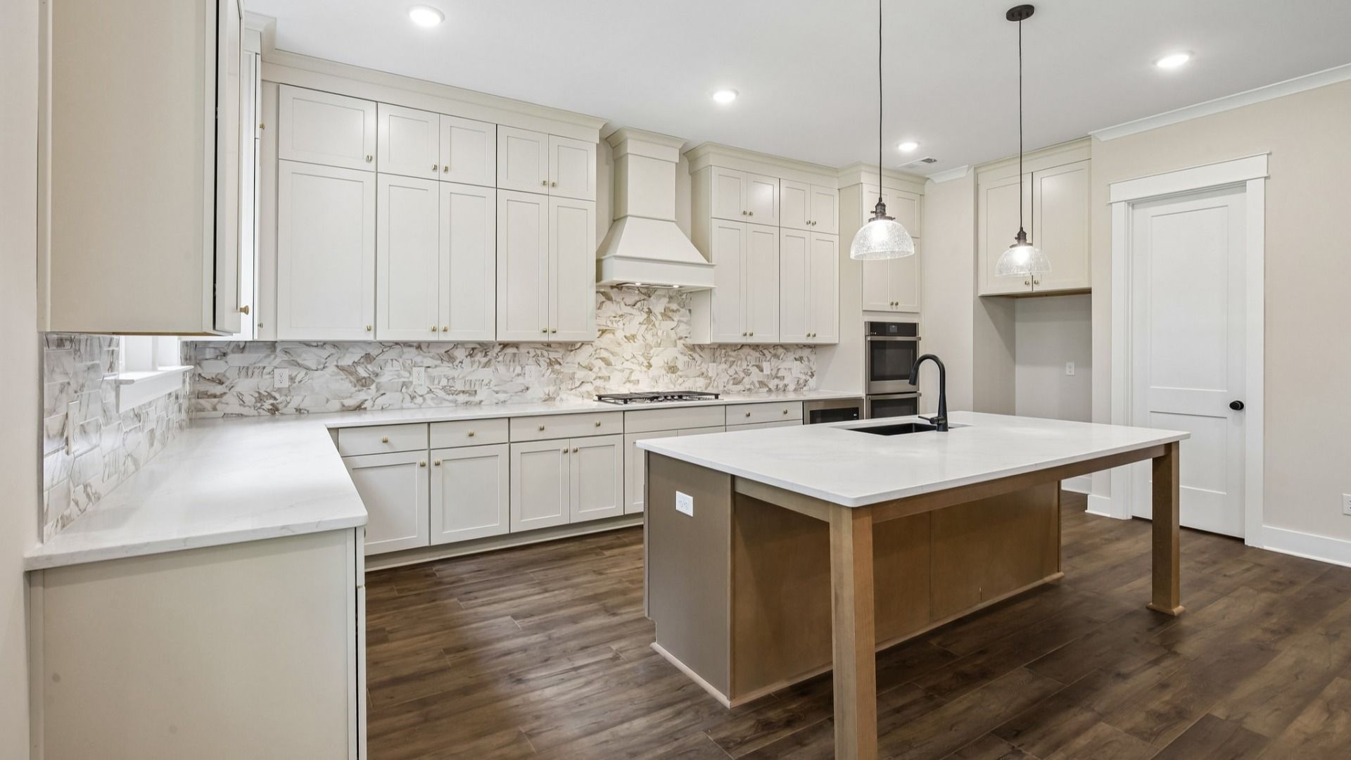 Kitchen with quartz countertops, tile backsplash, and pendant lighting