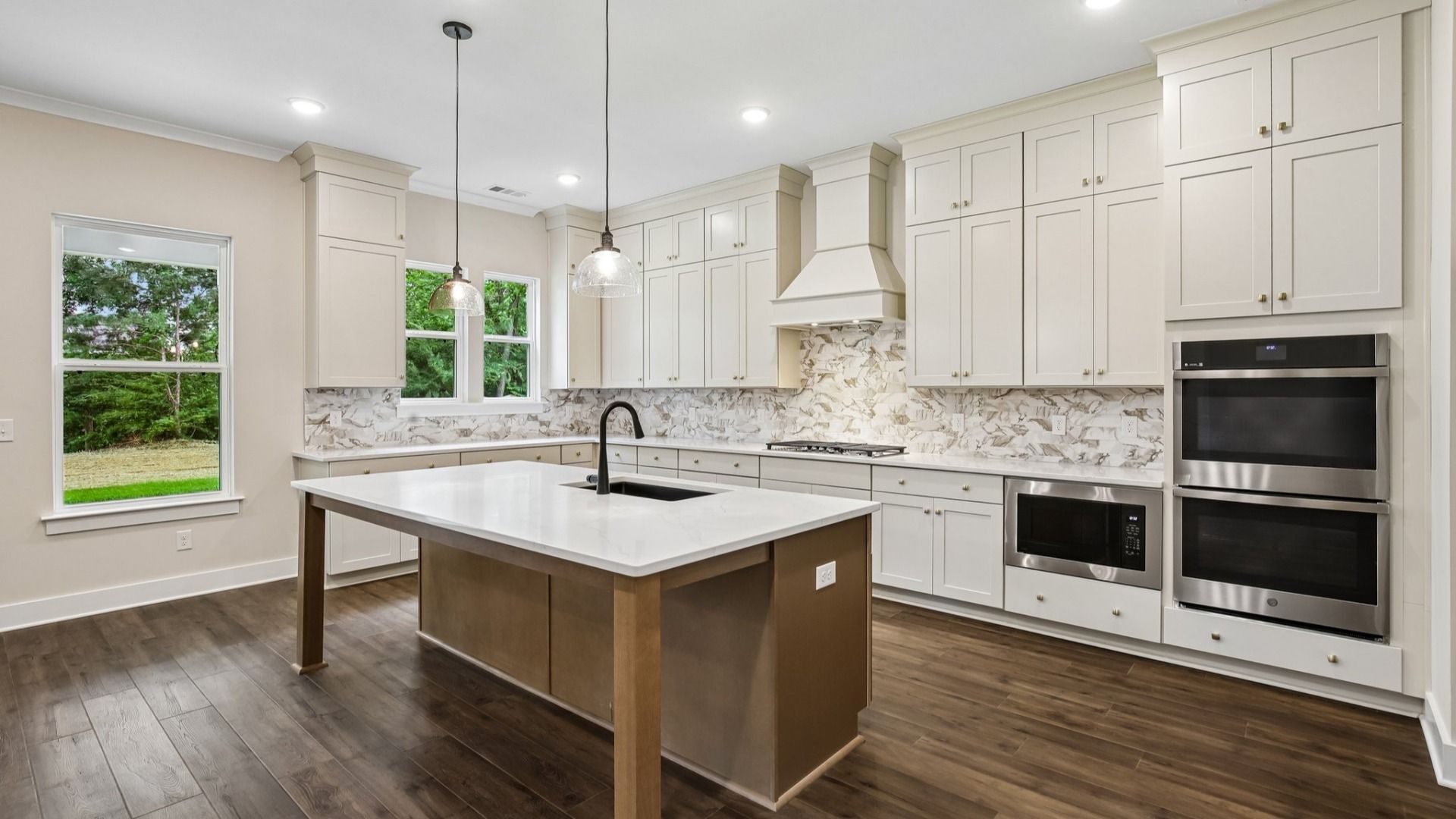 Kitchen with quartz countertops, tile backsplash, and pendant lighting