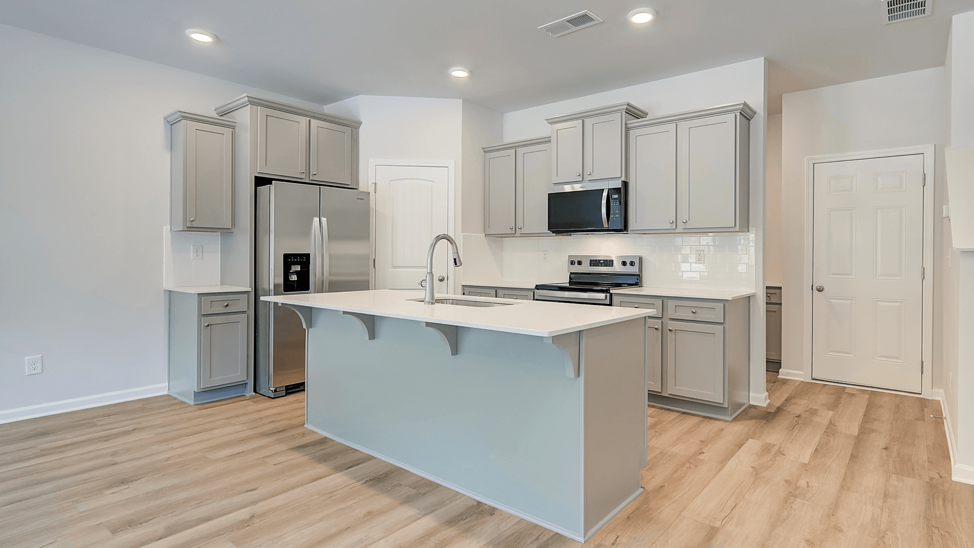 Kitchen with quartz countertops, tile backsplash, and hard surface flooring