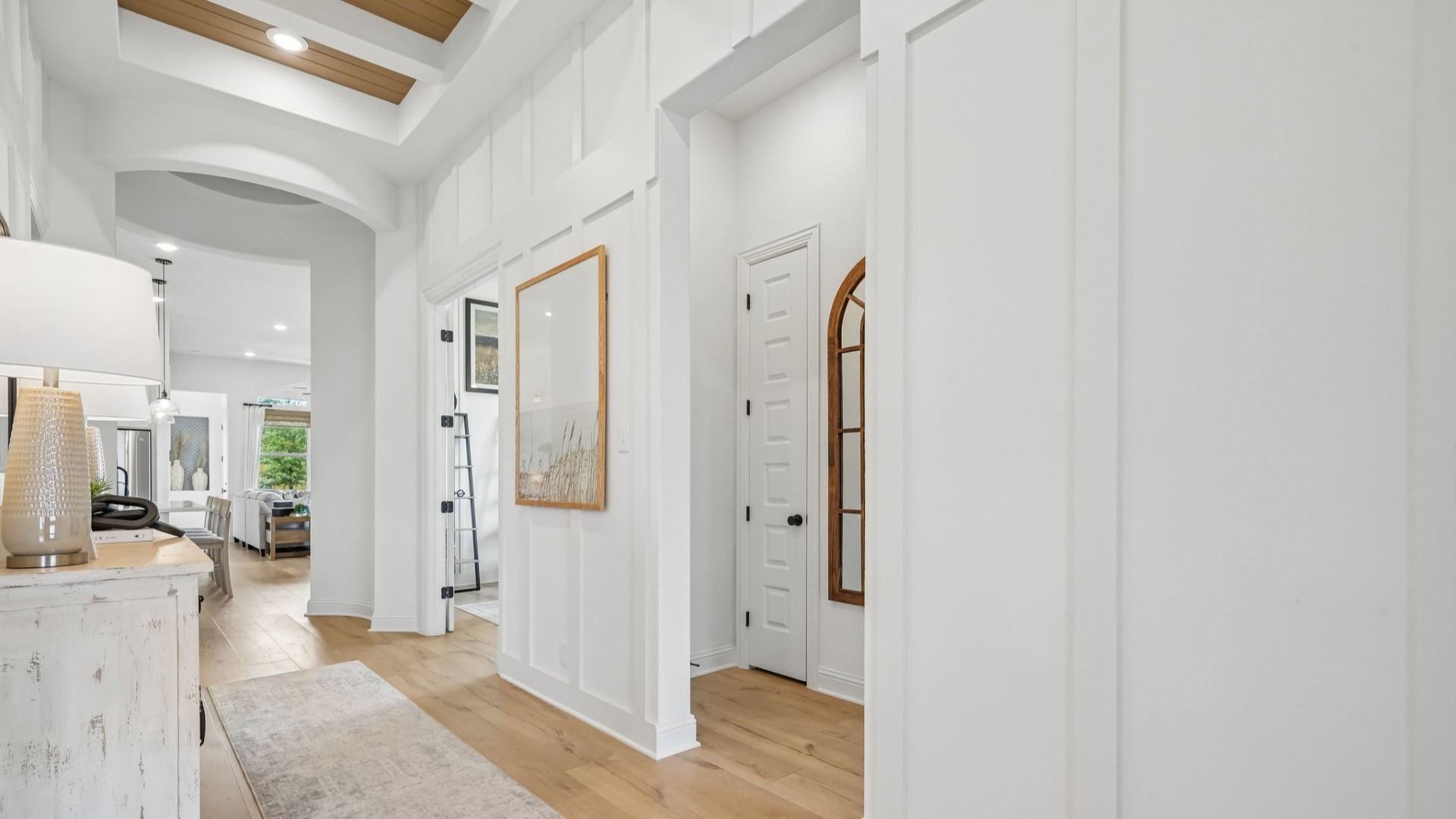 Bright white foyer featuring a rotunda, natural wood accents, and sophisticated interior design