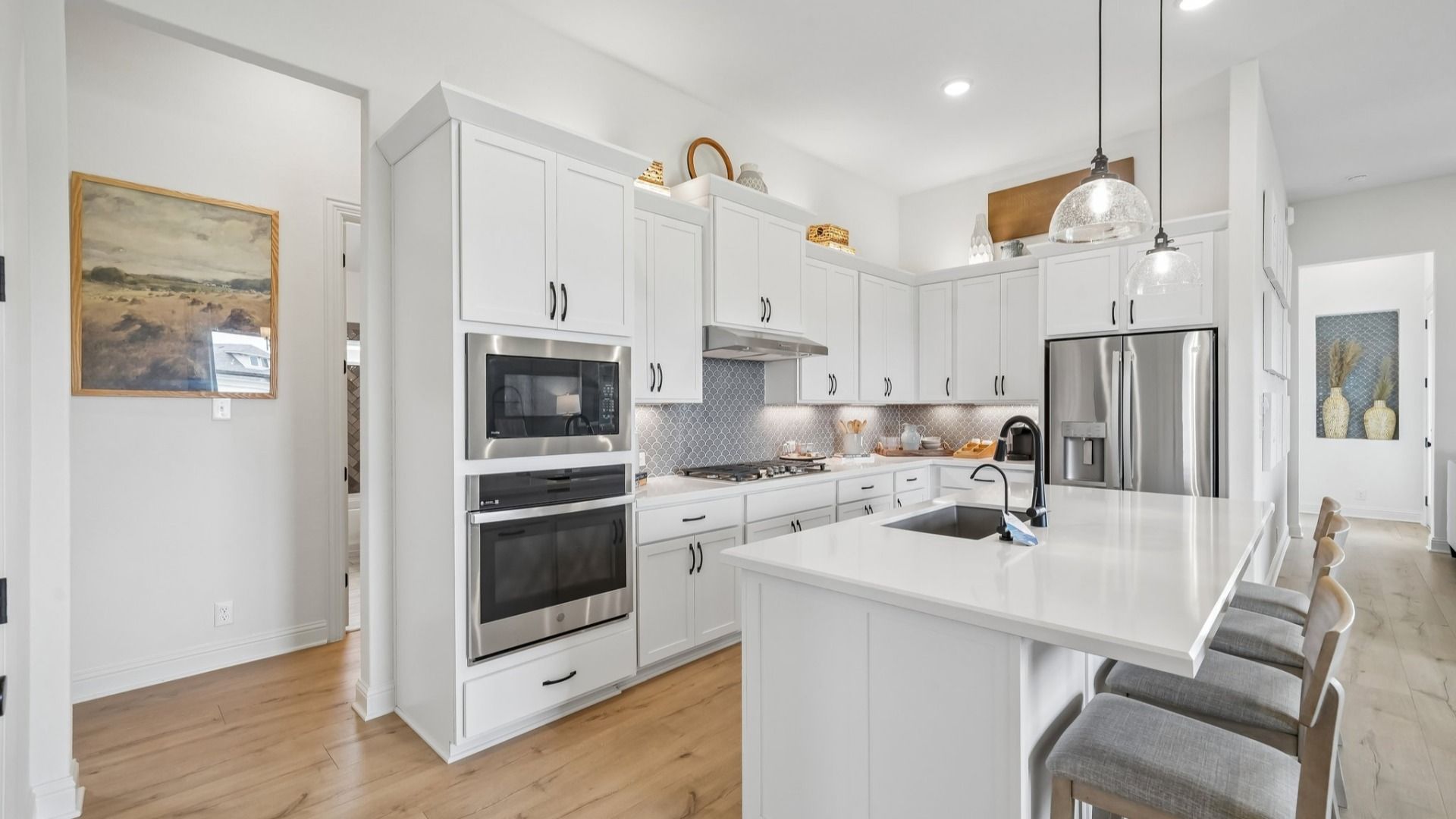 Sleek kitchen design with gas cooktop, vent hood, built-in oven, and modern finishes