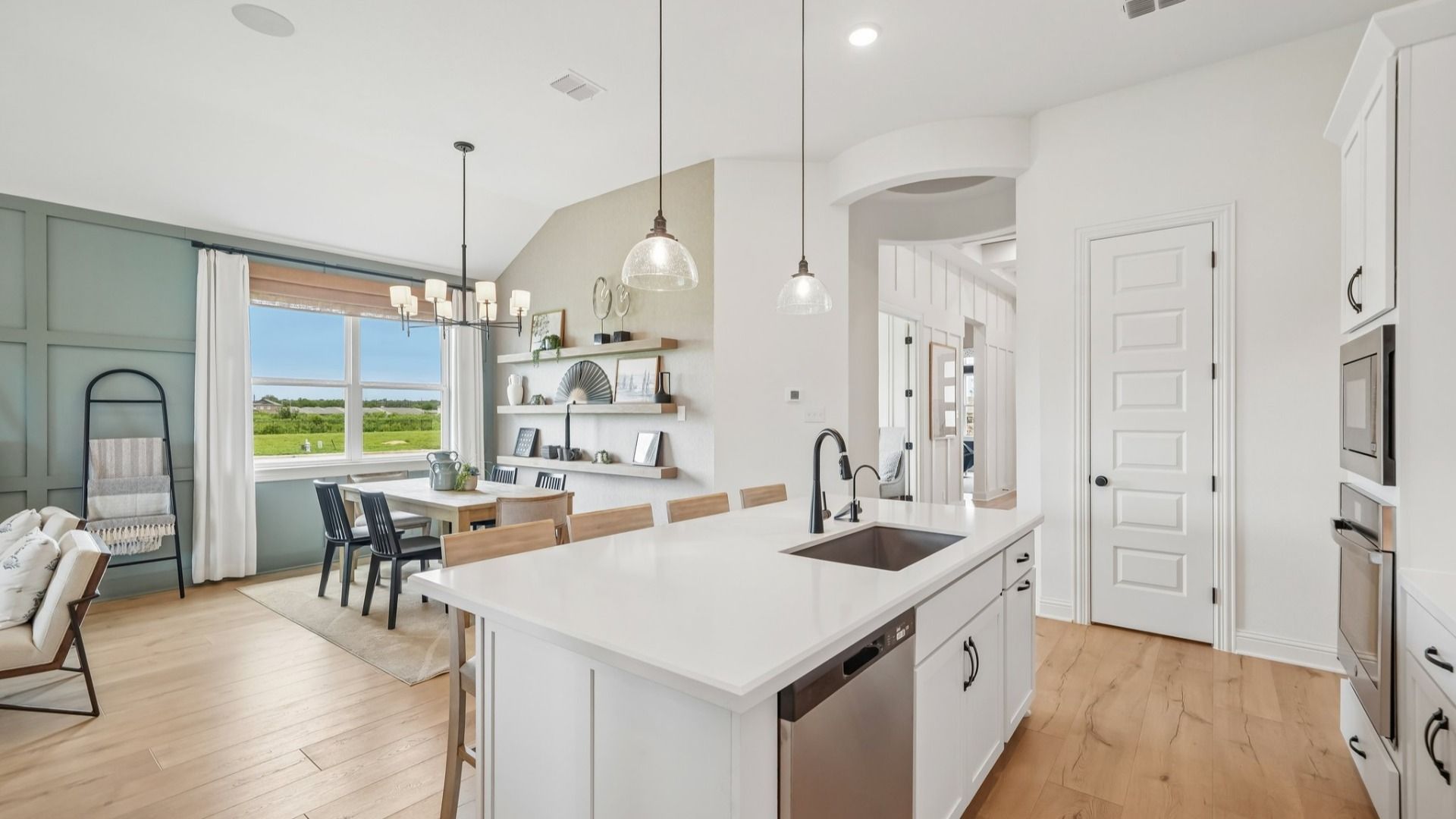 Elegant kitchen with gray scalloped backsplash, glass pendant lighting, center island, and ambient accent lighting