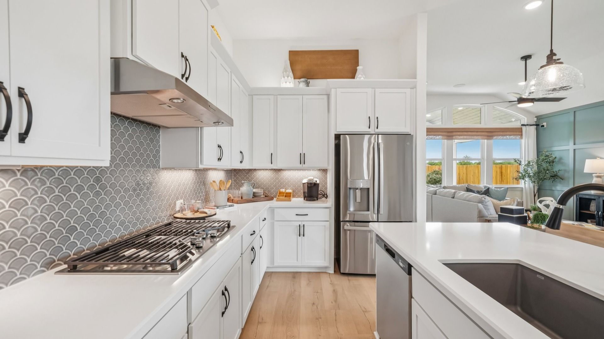 Sleek kitchen design with gas cooktop, vent hood, built-in oven, and modern finishes