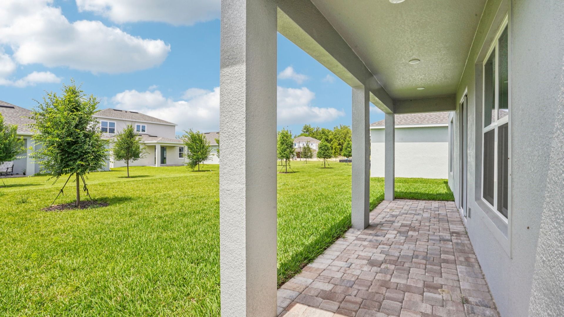 Covered lanai with scenic backyard views in the Plumeria plan at Lakeside at Satilla by DRB Homes.