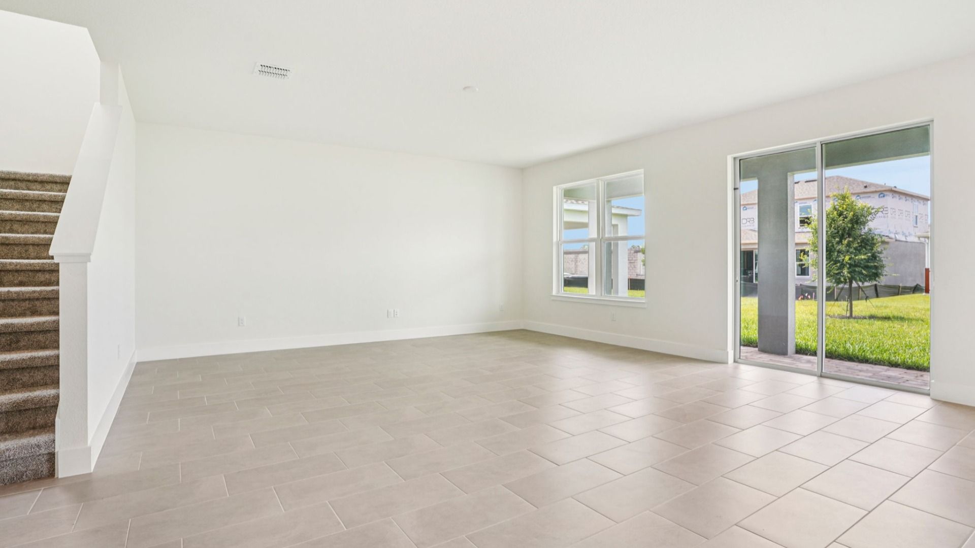 Bright open concept living and dining area in the Plumeria plan at Lakeside at Satilla by DRB Homes.