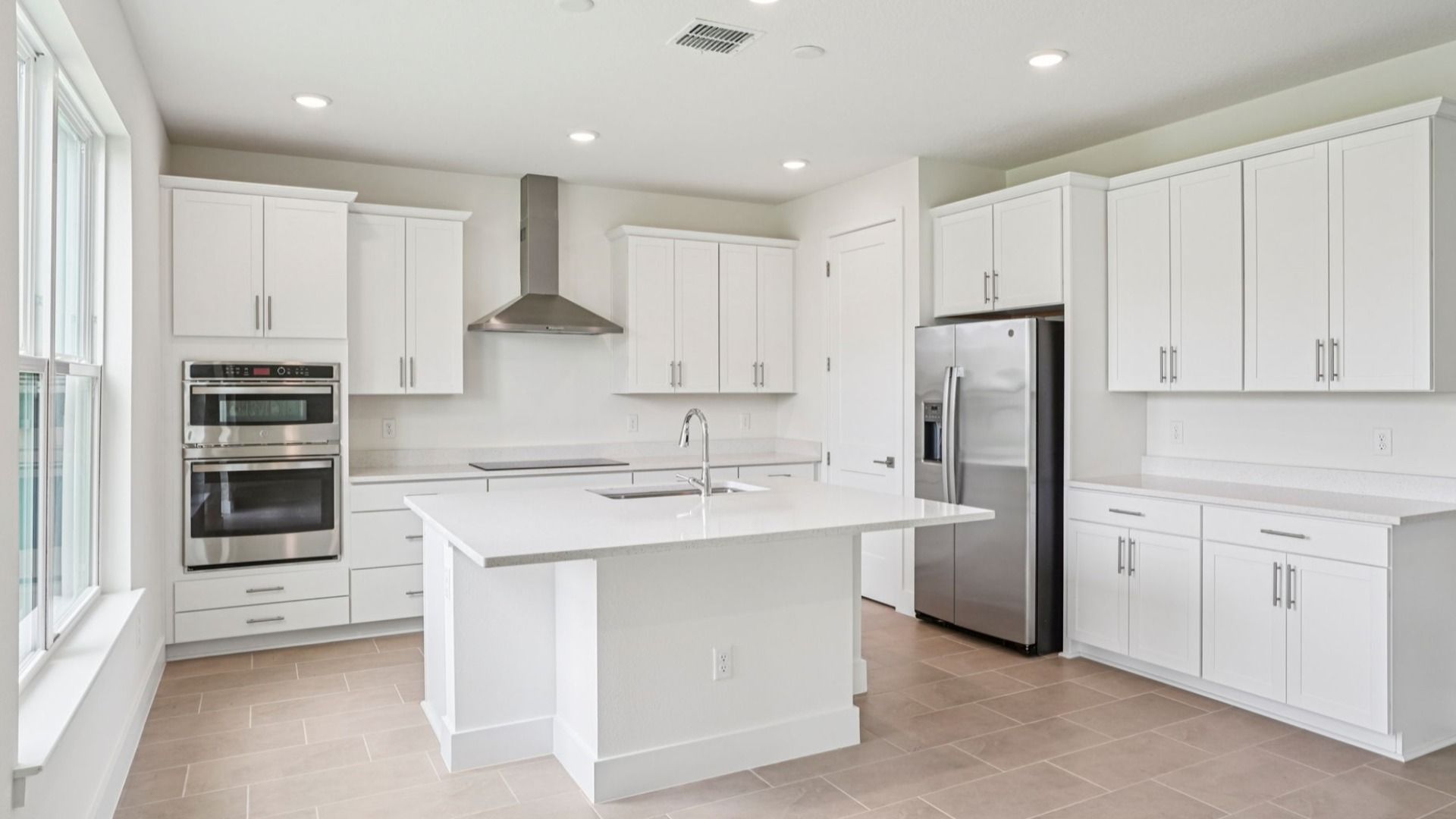 Gourmet kitchen featuring quartz island and stainless appliances at Lakeside at Satilla by DRB Homes.
