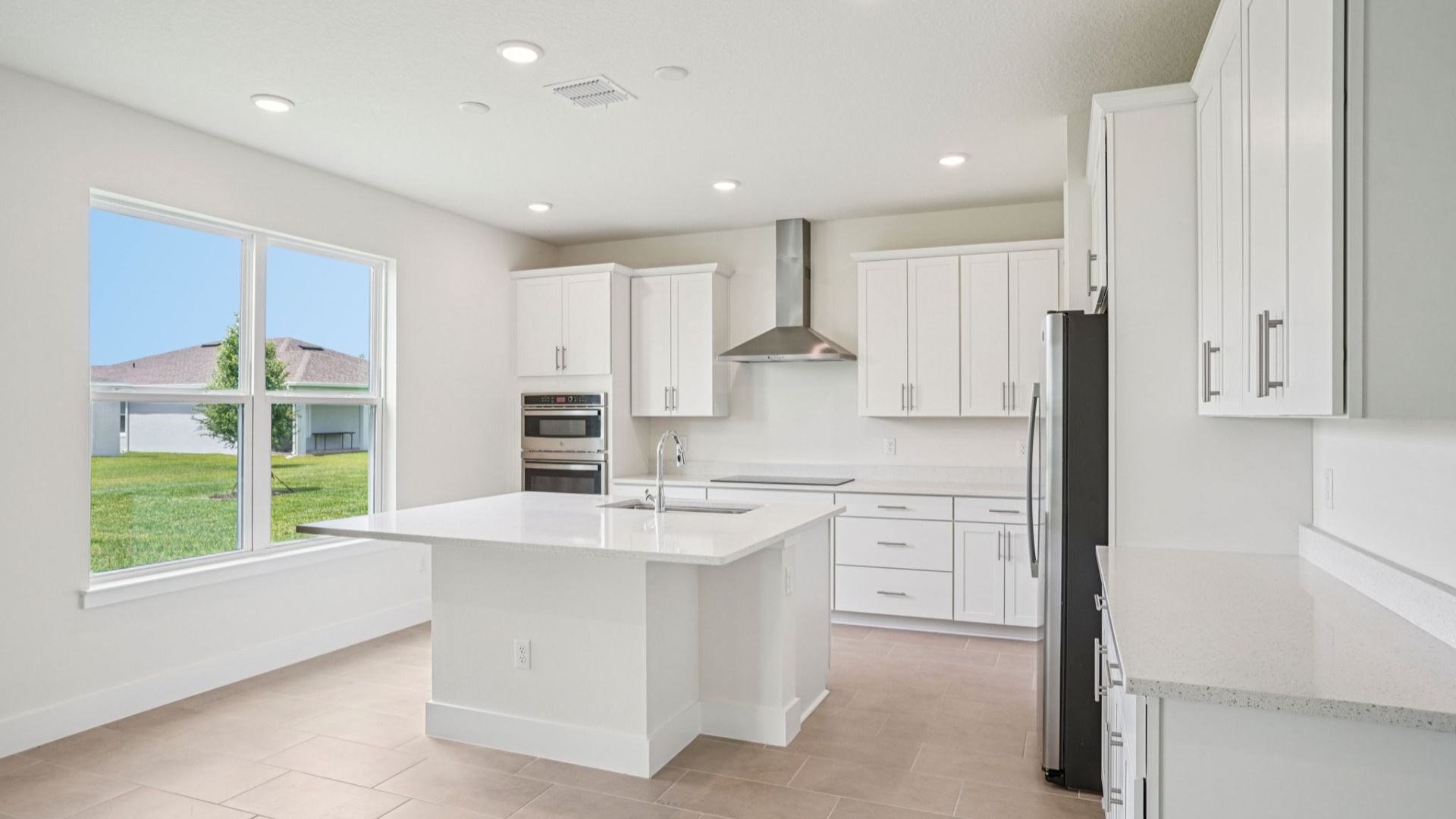 Bright open kitchen with large windows and center island in the Plumeria at Lakeside at Satilla.