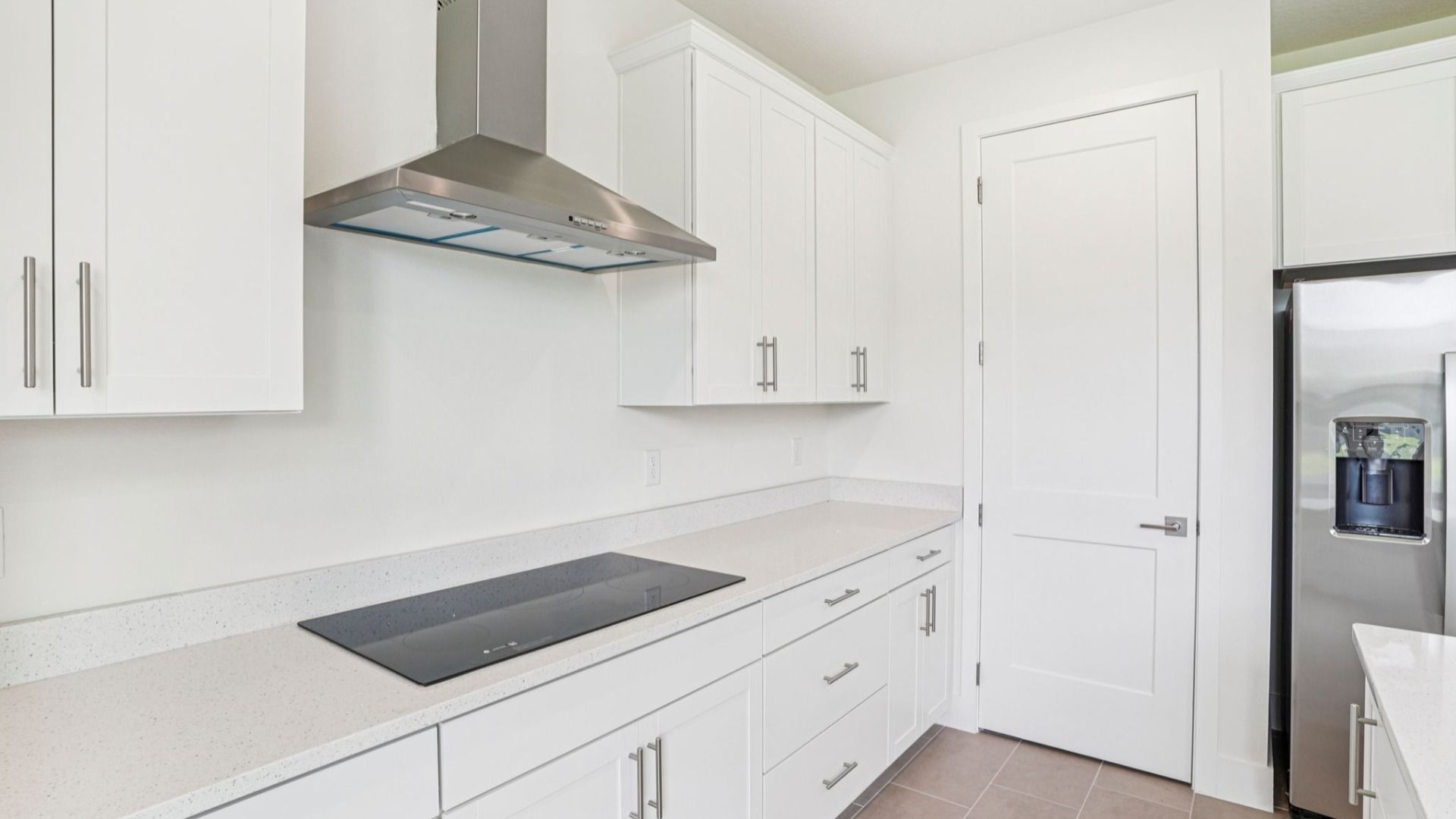 Chef's kitchen with gas cooktop and range hood in the Plumeria at Lakeside at Satilla by DRB Homes.