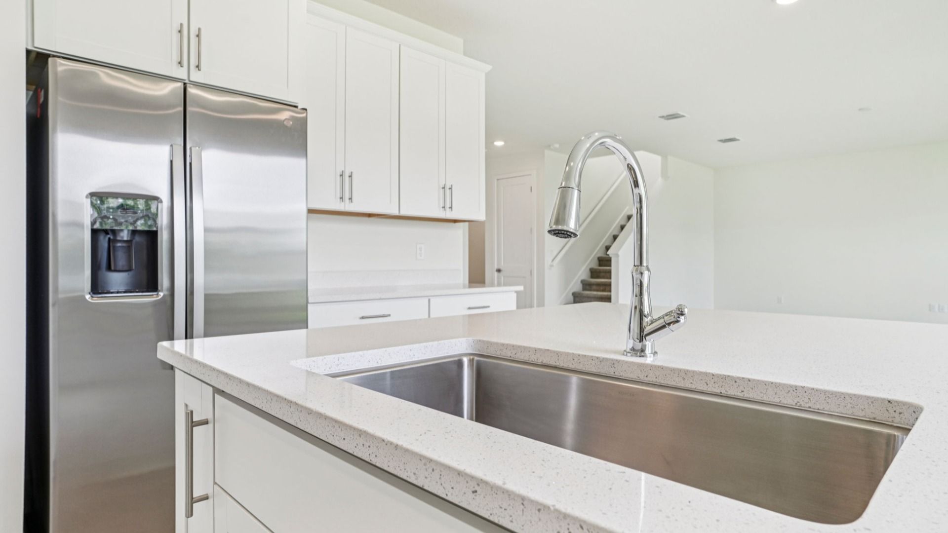 Kitchen with stainless appliances and sink in the Plumeria plan at Lakeside at Satilla by DRB Homes.
