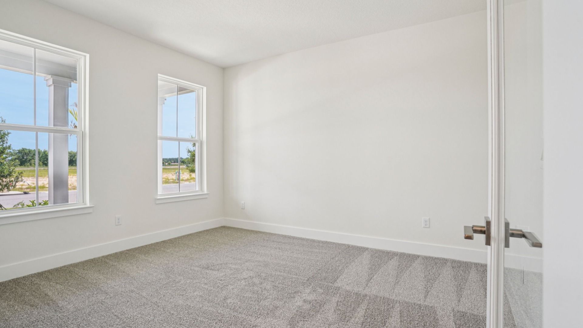 Spacious owner's suite with plush carpet in the Plumeria plan at Lakeside at Satilla by DRB Homes.