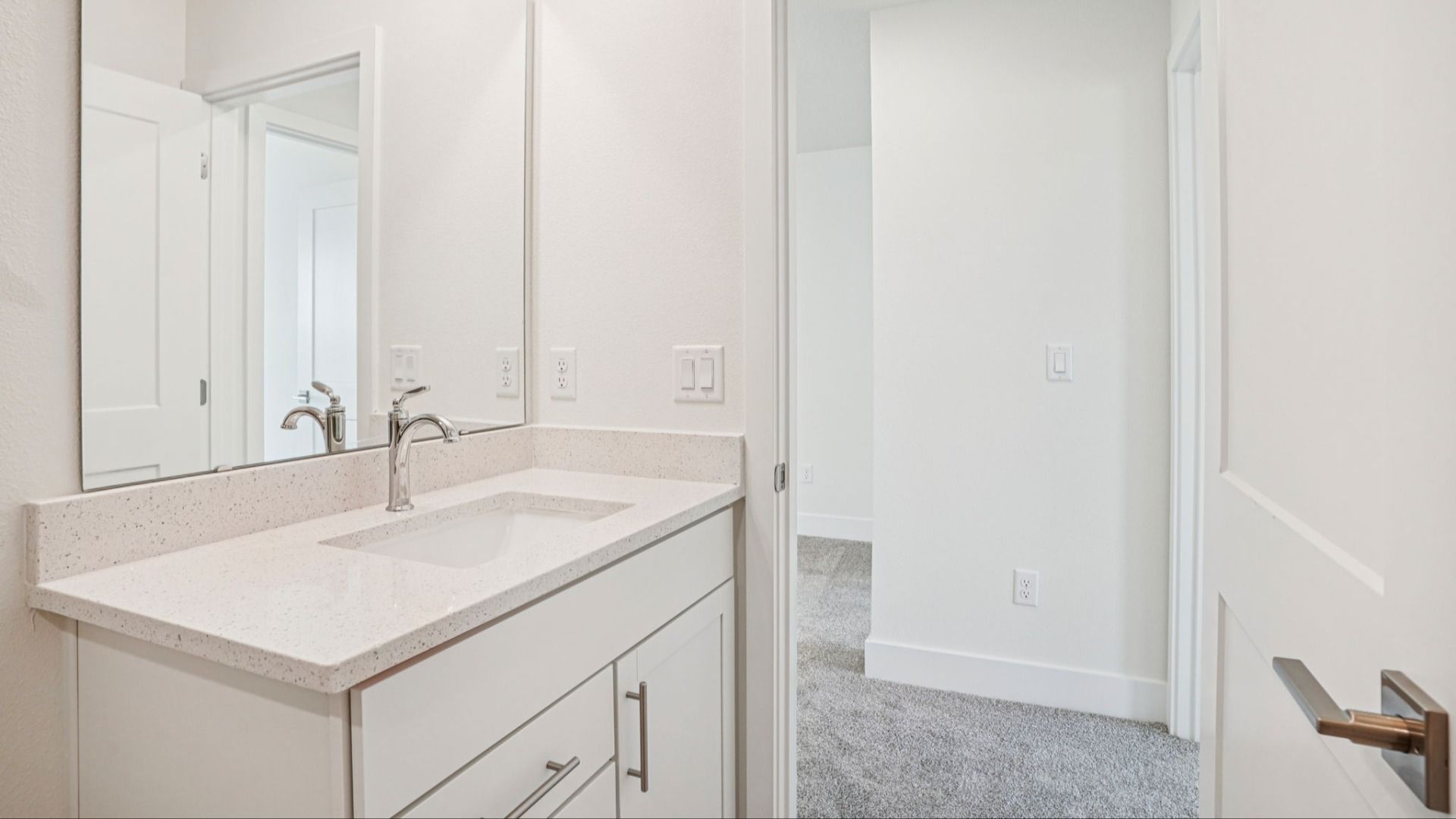 Bathroom with dual vanity and mirrors in the Plumeria plan at Lakeside at Satilla by DRB Homes.