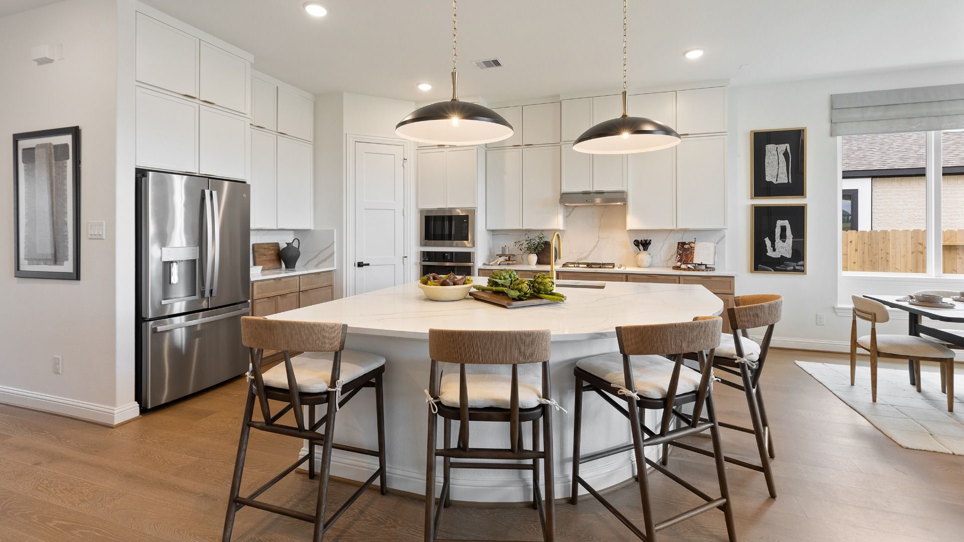 Spacious, bright kitchen featuring white cabinetry and a large island in the Rosewood Model in Grand Magnolia.