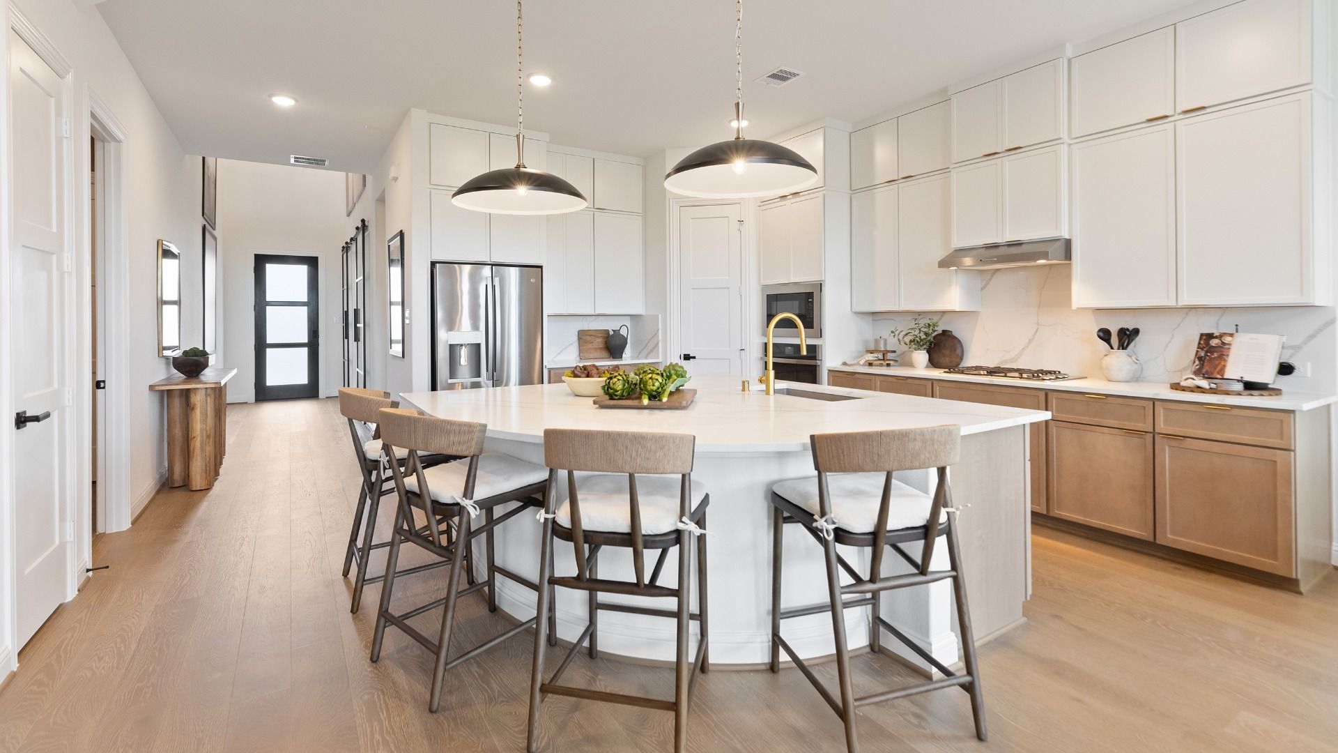 Spacious, bright kitchen featuring white cabinetry and a large island in the Rosewood Model in Grand Magnolia.