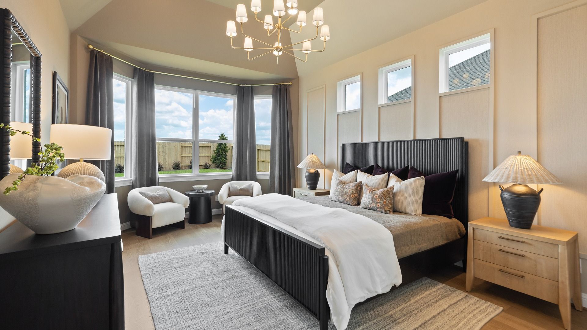Stunning primary bedroom in Rosewood model with chic accents, bold decor, and an elevated bay window.