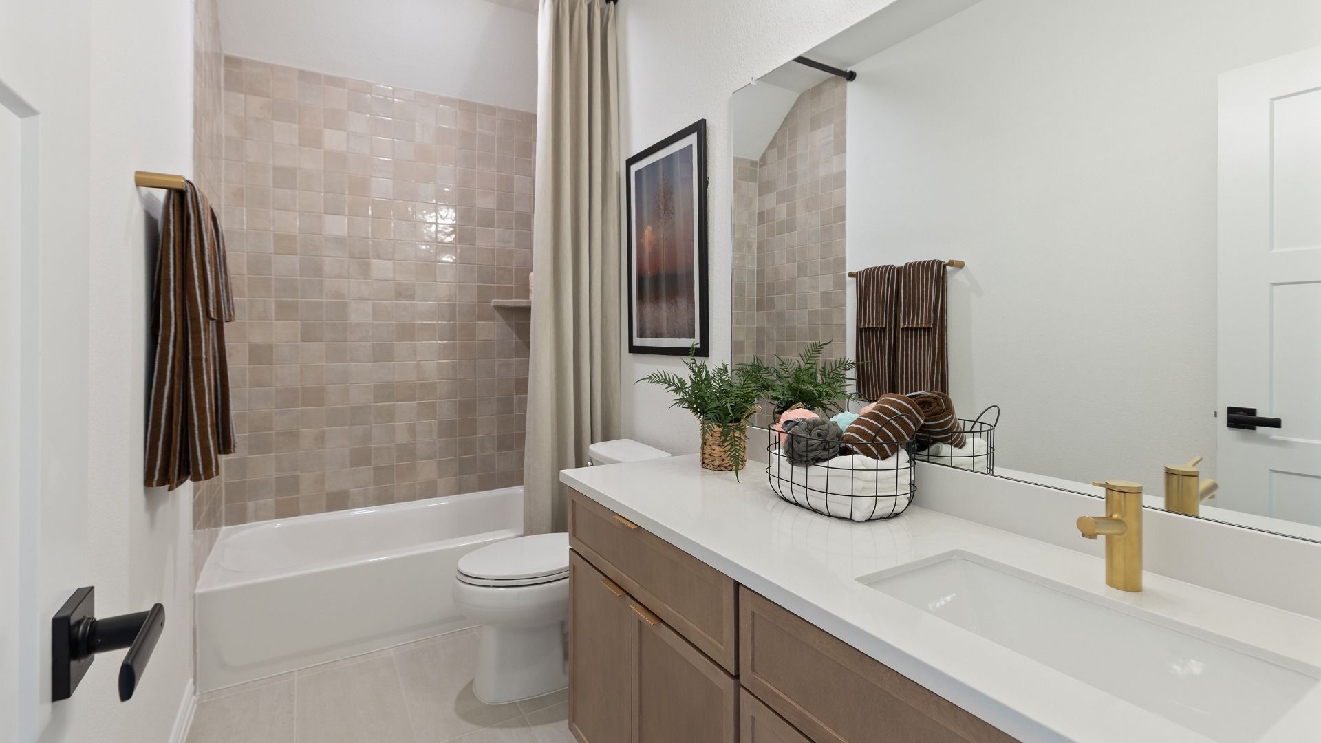 Additional upstairs bathroom with natural tones throughout and clean, white counters.