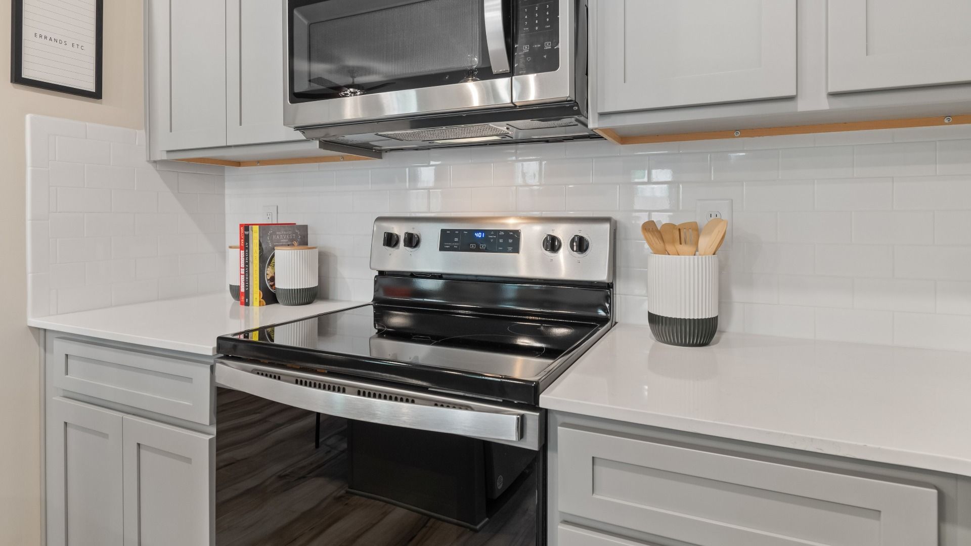 Kitchen with grey cabinetry, quartz countertops, and tile backsplash