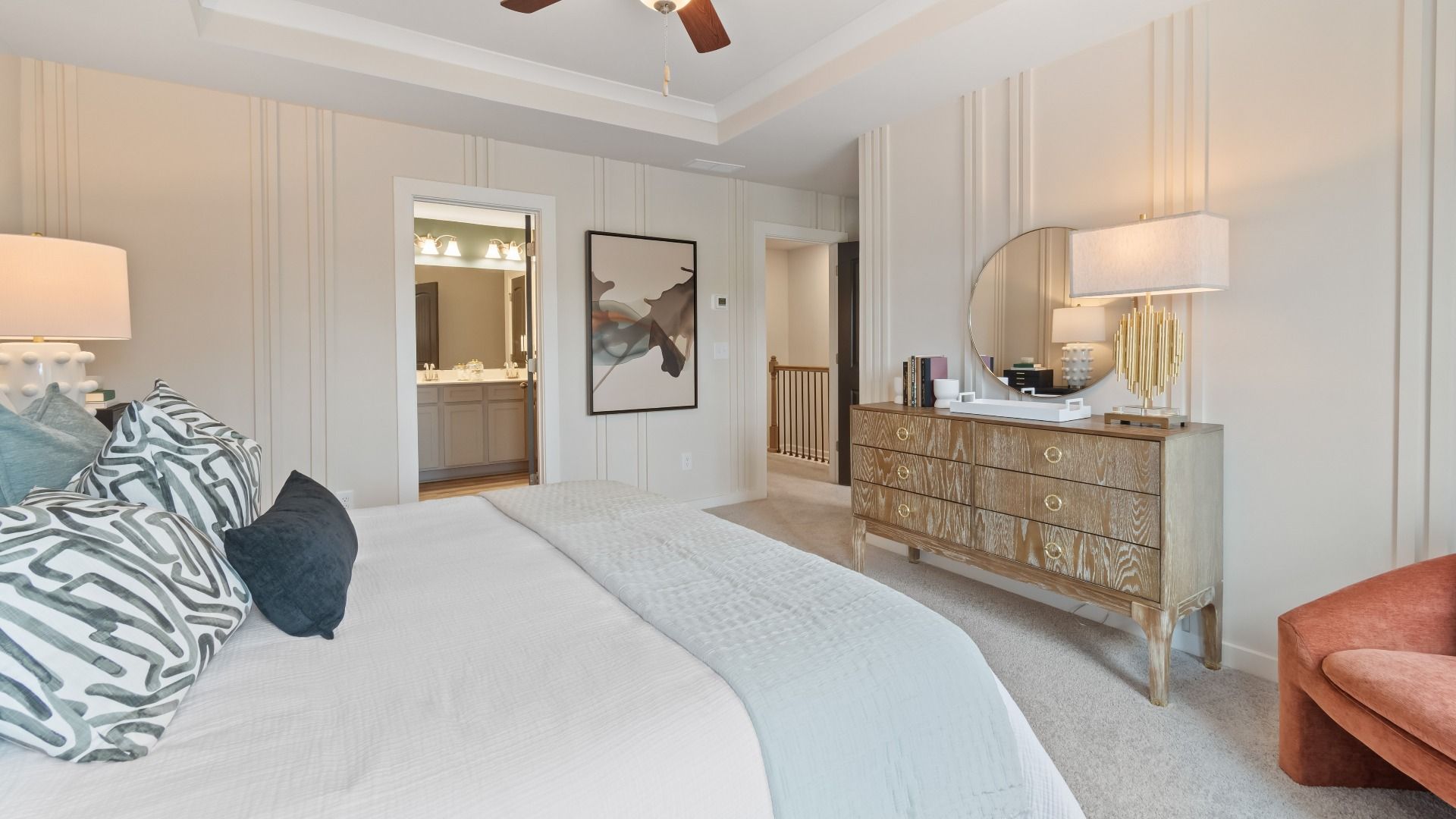 Primary Bedroom with tray ceiling, accent walls, carpet, ceiling fan, and windows