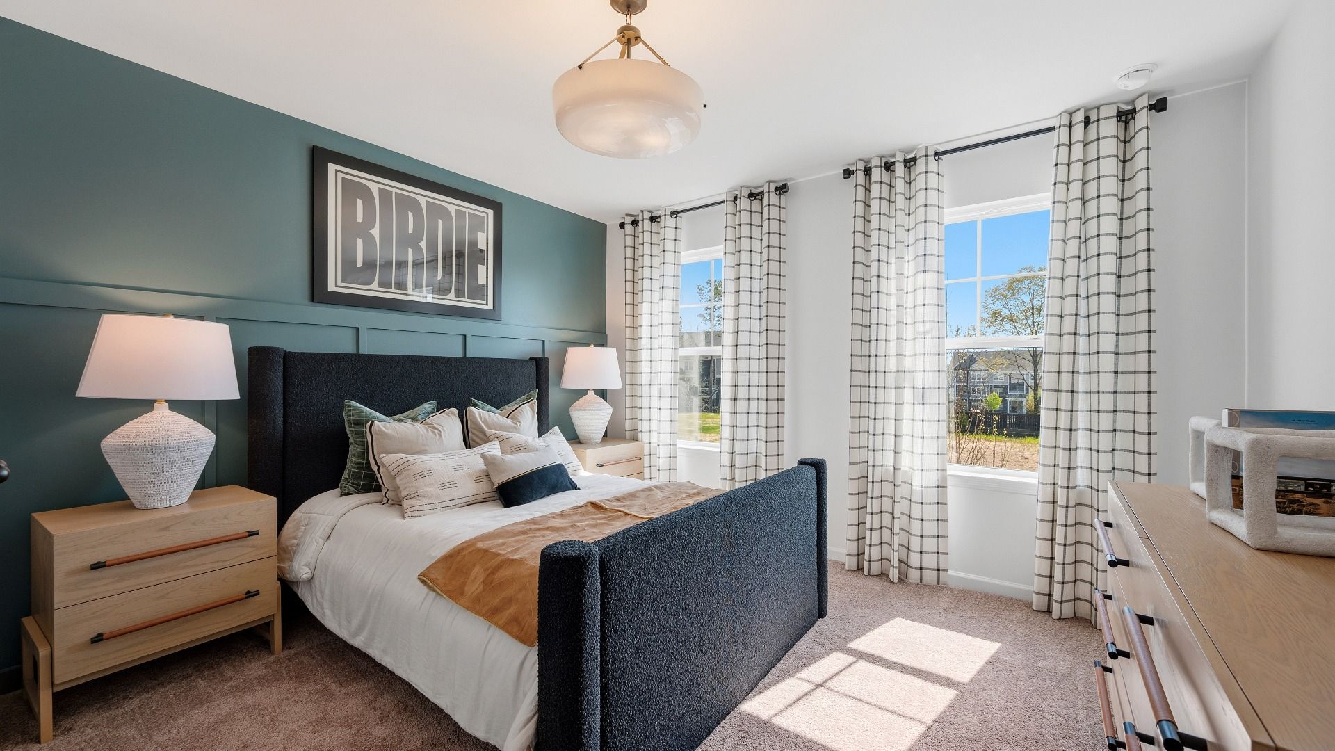 Bedroom with accent wall, carpet, and windows