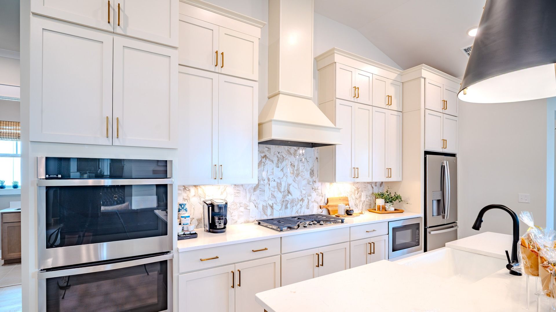 Kitchen with light cabinetry, quartz countertops, and tile backsplash
