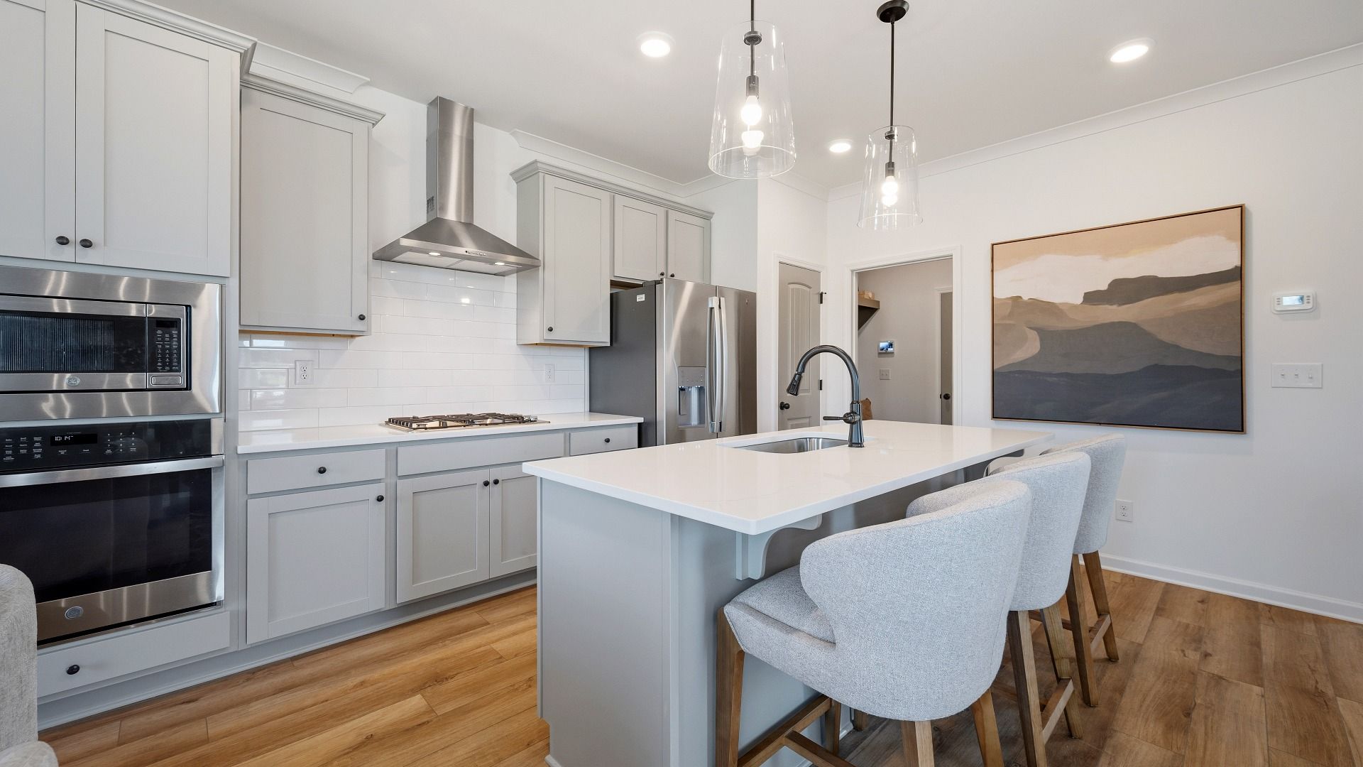 Spacious kitchen with tile backsplash, quartz countertops, and pendant lighting
